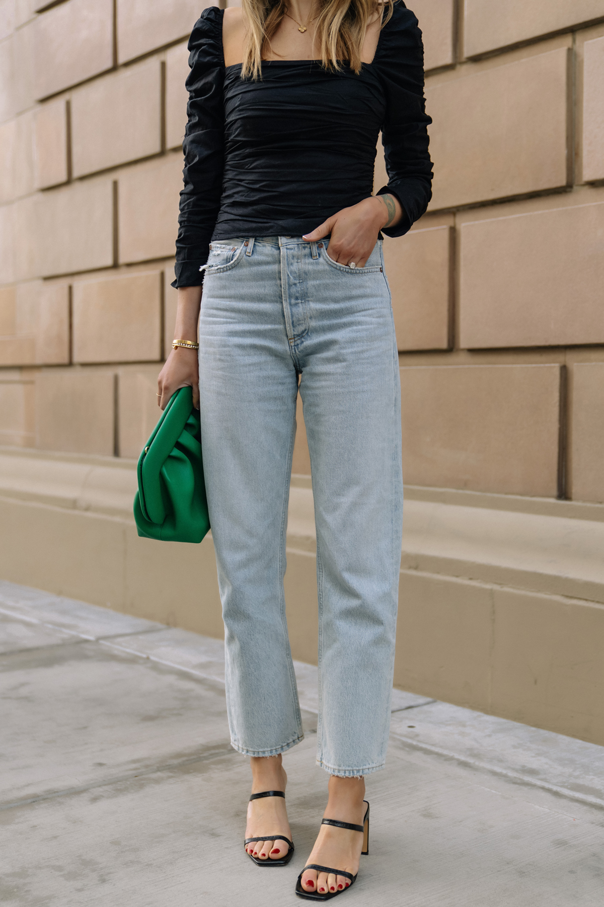 Fashion Jackson Wearing Black Rouched Reformation Top AGOLE 90s Loose Fit Jeans Black Heeled Sandals Green Clutch