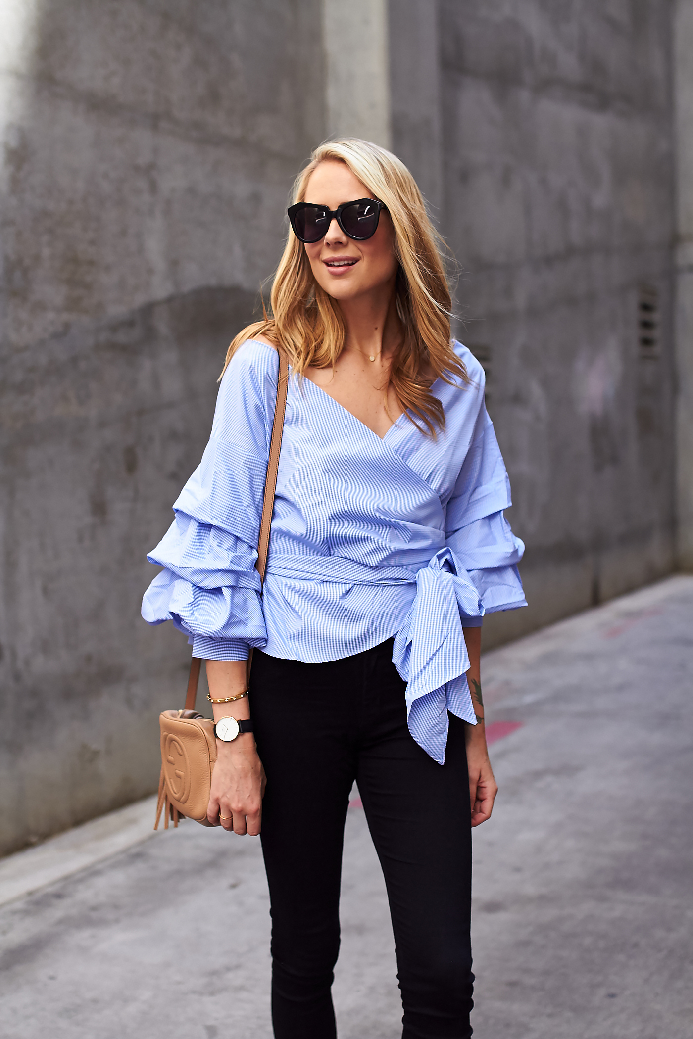fashion-jackson-blue-ruffle-sleeve-wrap-blouse-black-skinny-jeans-gucci-soho-handbag-karen-walker-sunglasses