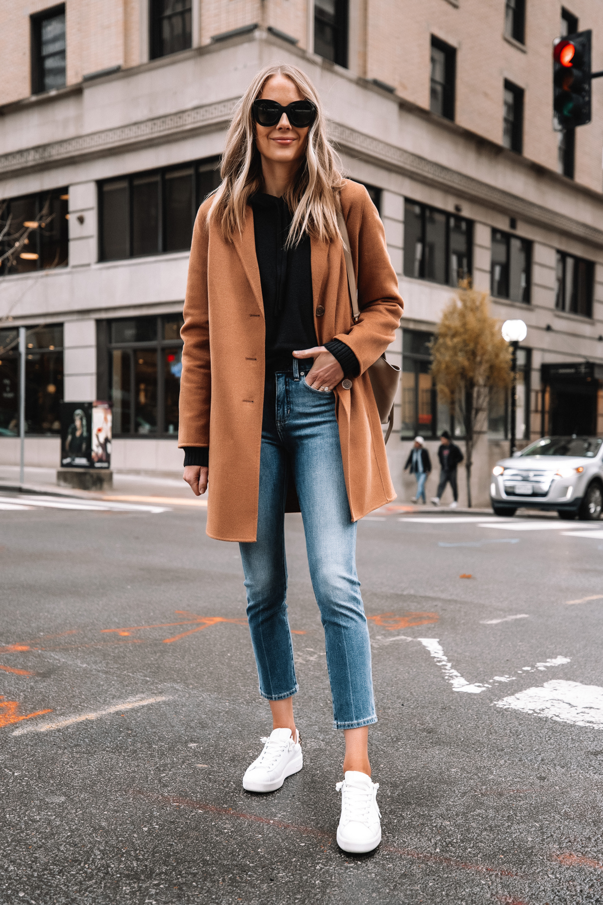 Fashion Jackson Wearing Banana Republic Camel Coat Black Hoodie Sweater Denim Ankle Jeans White Sneakers Street Style