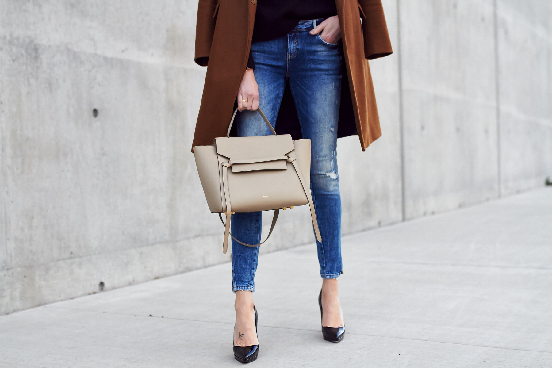 Fall Outfit, Winter Outfit, Tan Topcoat, Black Sweater, Denim Ripped Skinny Jeans, Celine Tie Belt Bag, Black Louboutin Pumps