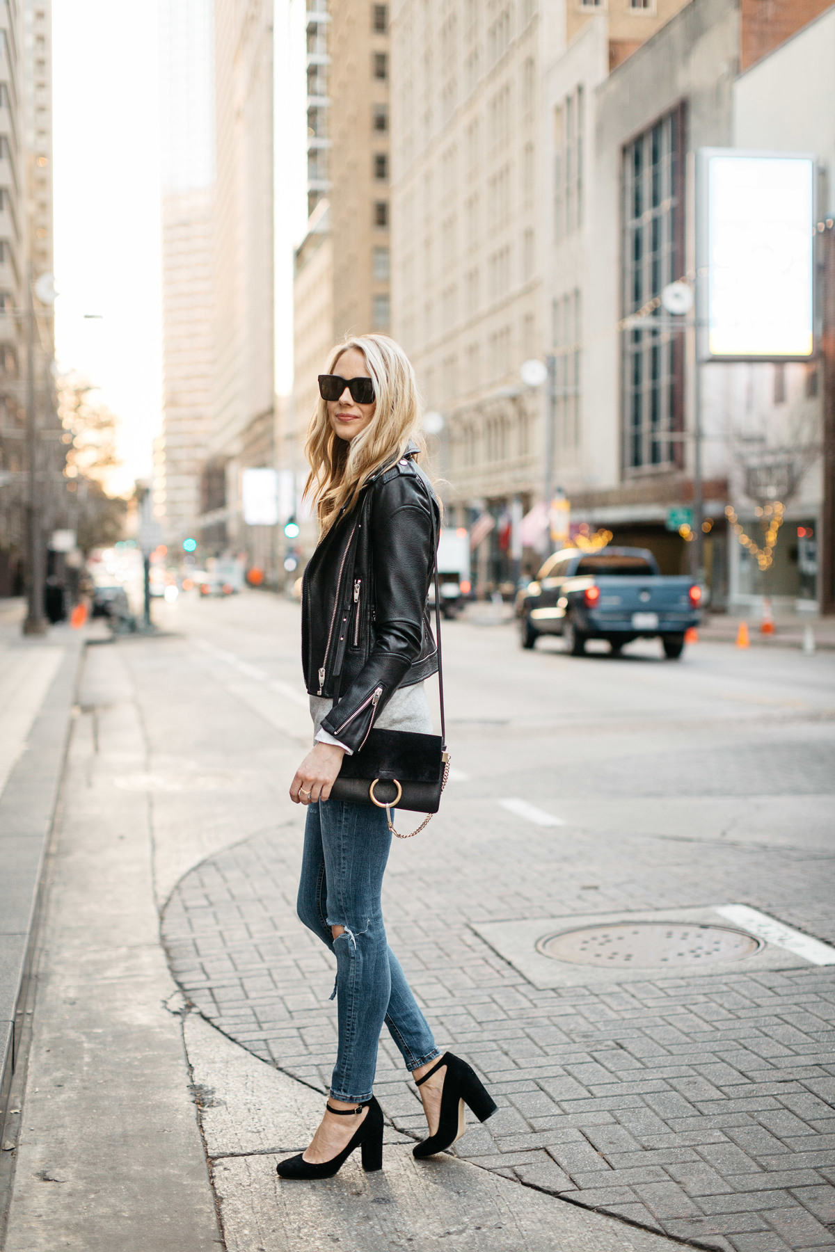 Fall Outfit, Winter Outfit, Black Leather Jacket, Grey Sweater, White Button-Down Shirt, Denim Ripped Skinny Jeans, Black Ankle Strap Pumps, Chloe Faye Handbag