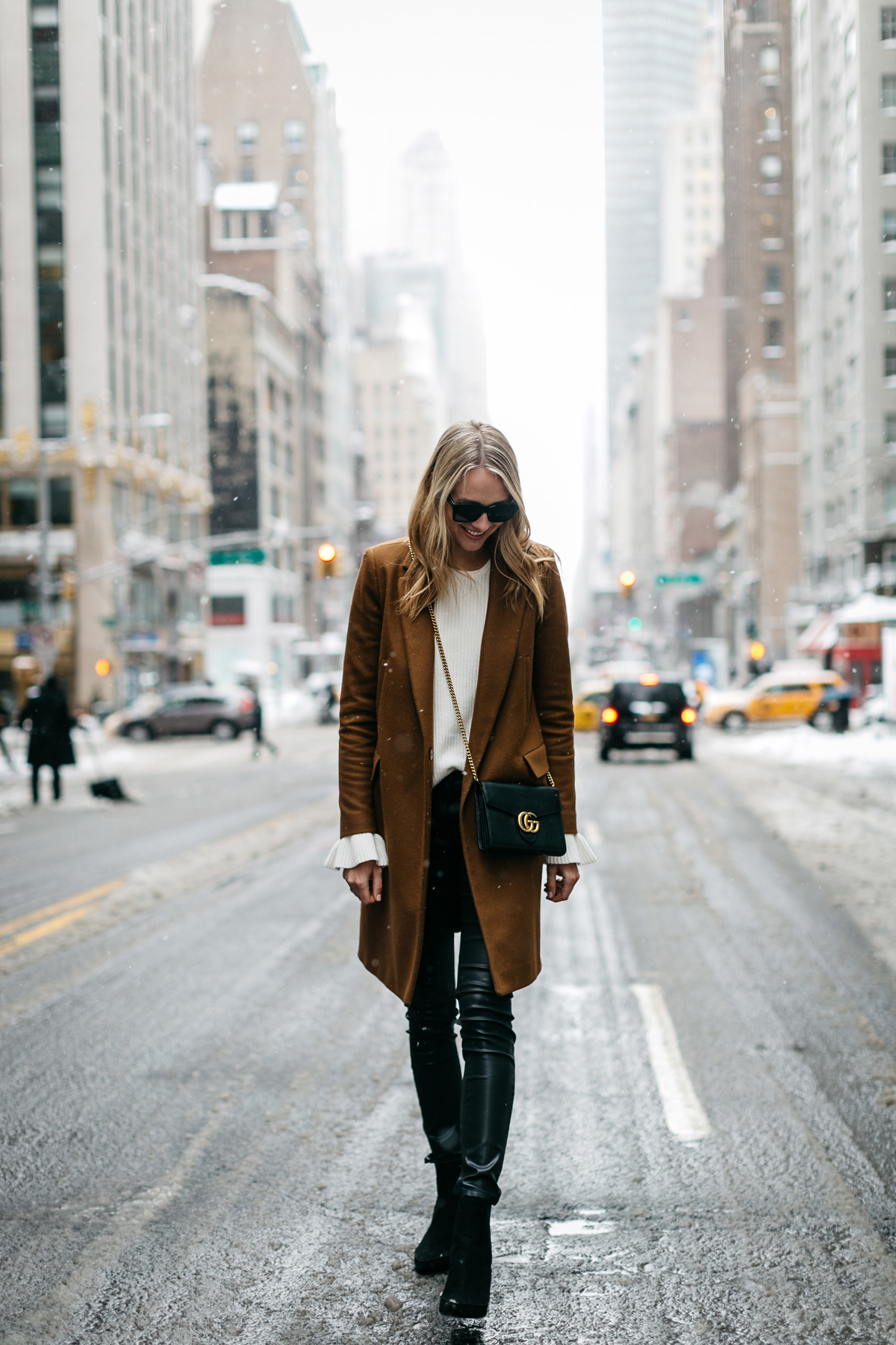NYFW, Winter Outfit, Camel Wool Coat, White Ruffle Sleeve Sweater, Black Faux Leather Pants, Black Booties, Gucci Marmont Handbag, Street Style
