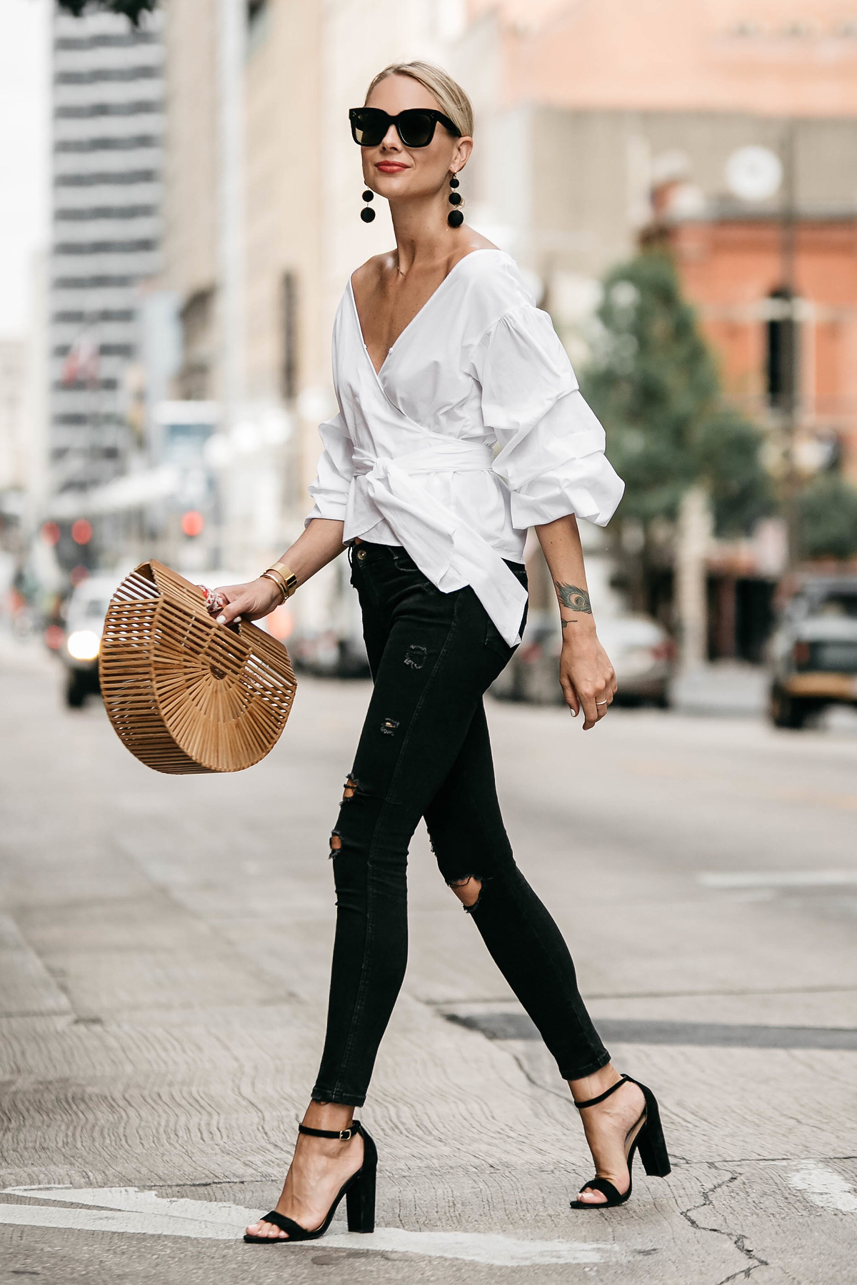 Blonde Woman Wearing Club Monaco Ruffle Sleeve Wrap Top Cult Gaia Ark Bag Black Ripped Skinny Jeans Street Style Outfit
