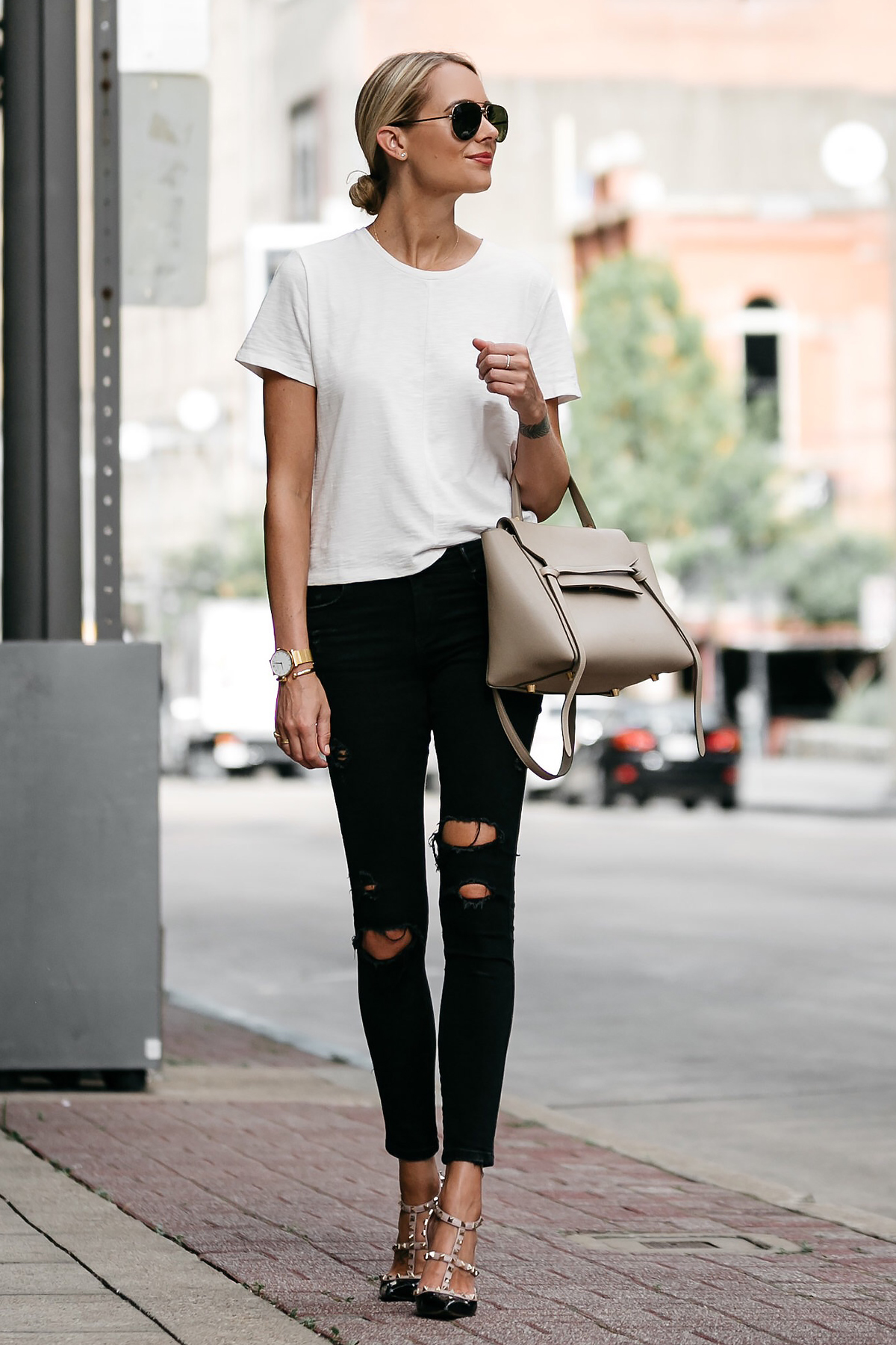 Sleek and chic: A young black woman poses in a fashionable white t-shirt  and black pants Stock Photo by Unai82