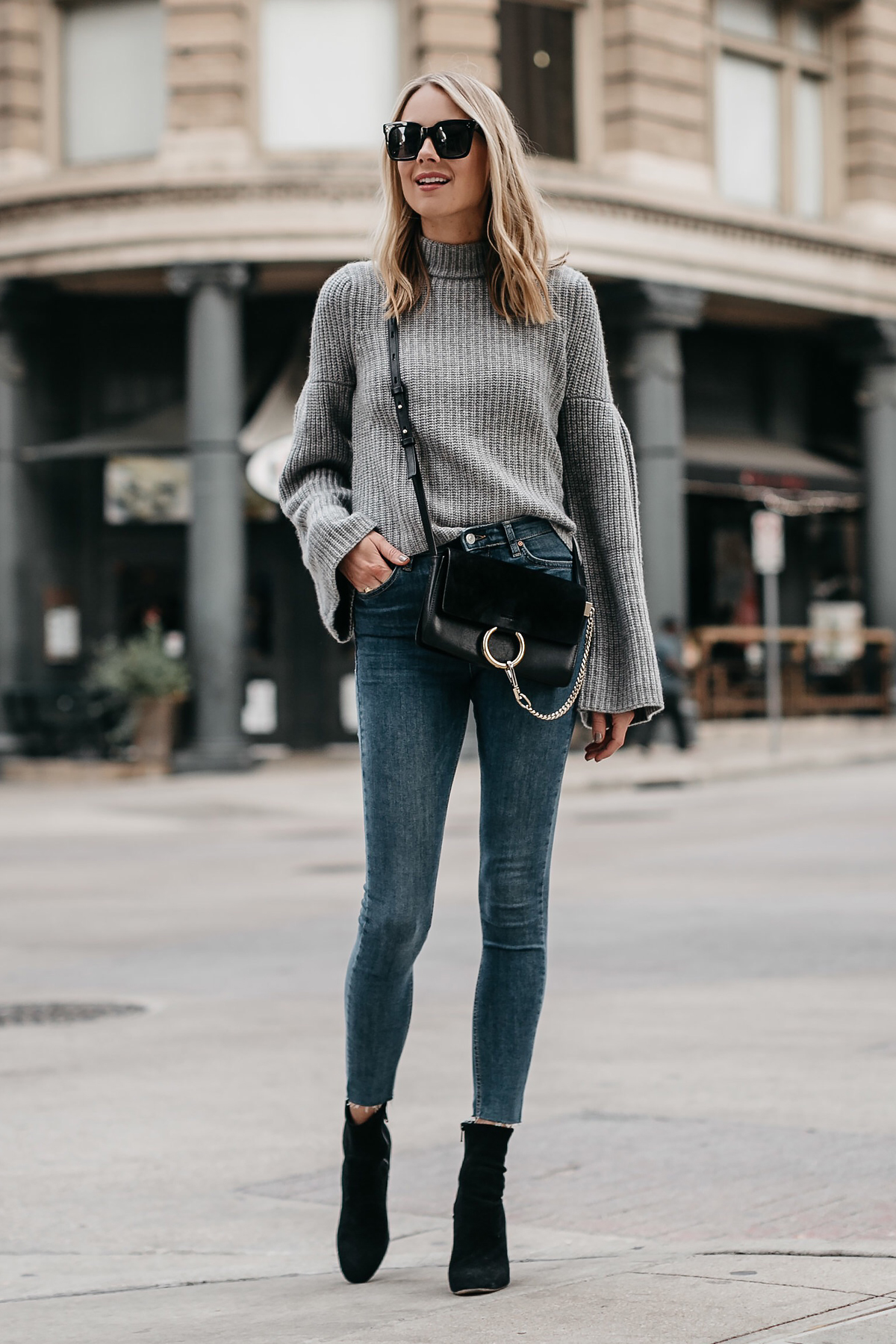 Blonde Woman Wearing Grey Bell Sleeve Sweater Denim Skinny Jeans Chloe Faye Black Handbag Black Booties Fashion Jackson Dallas Blogger Fashion Blogger Street Style