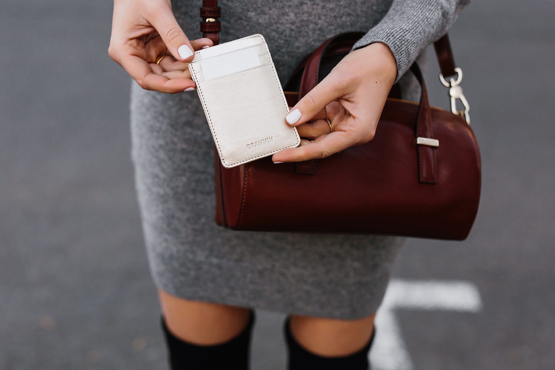 Woman Holding Brahmin Gold Card Case Brahmin Cognac Crossbody Grey Sweater Dress Fashion Jackson San Diego Fashion Blogger Street Style