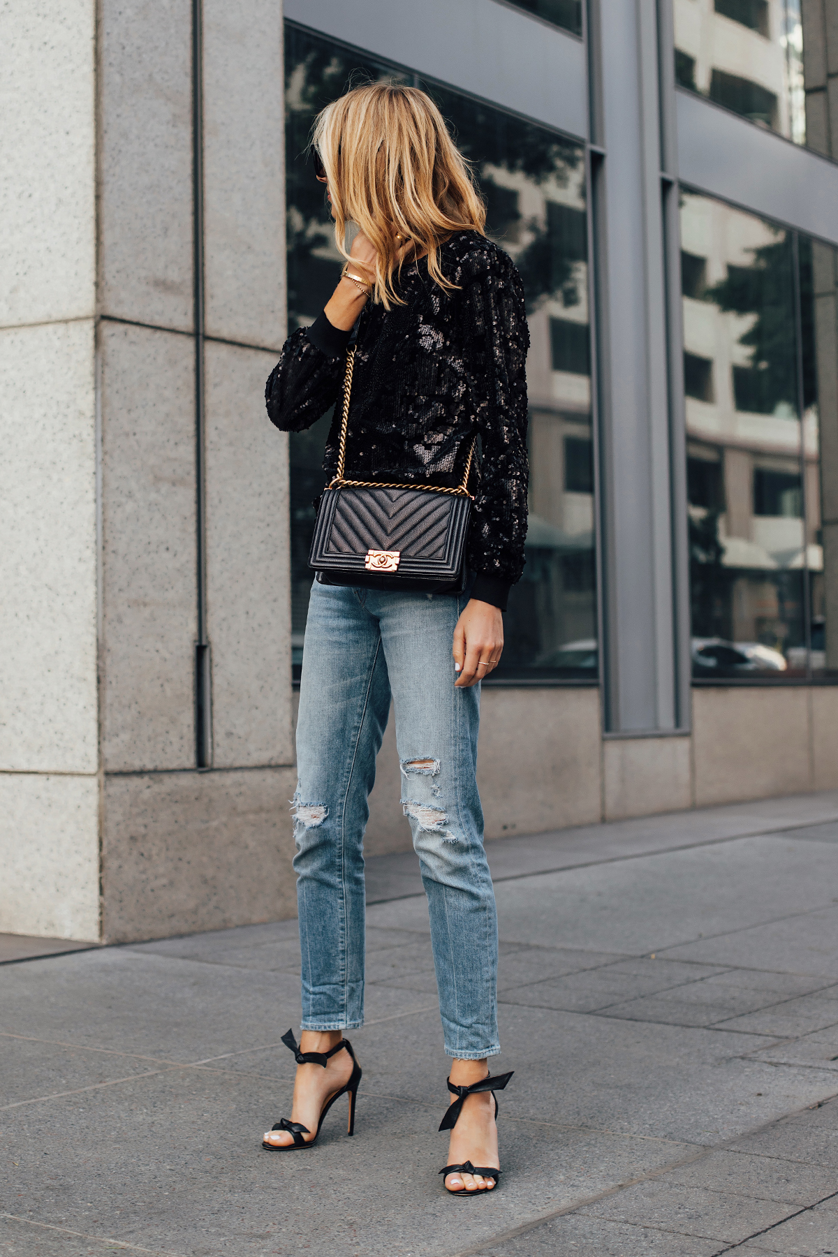 Blonde Woman Wearing Black Sequin Top Ripped Skinny Jeans Chanel Black Boy Bag Black Ankle Tie Heeled Sandals Fashion Jackson San Diego Fashion Blogger Street Style NYE Outfit