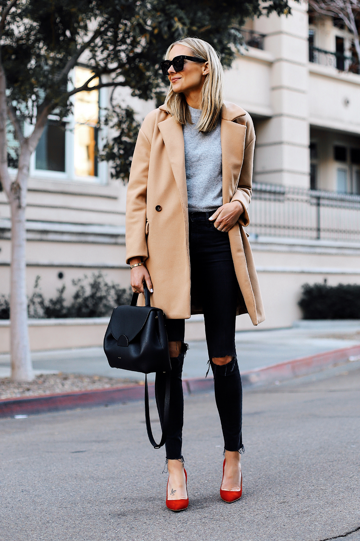Blonde Woman Wearing Camel Coat Grey Sweater Black Ripped Skinny Jeans Red Pumps Outfit Black Satchel Handbag Fashion Jackson San Diego Fashion Blogger Street Style