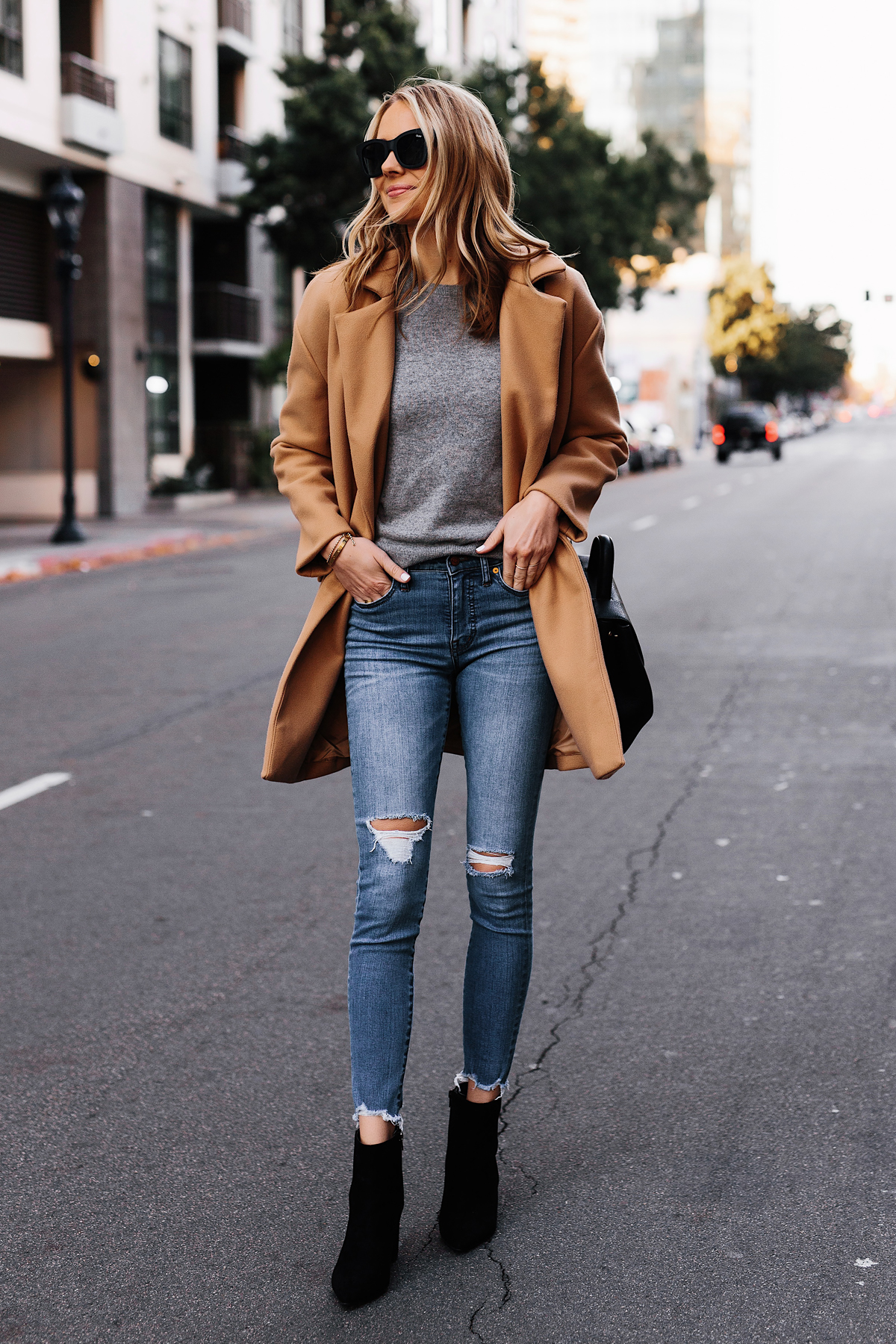 Blonde Woman Wearing Camel Coat Grey Sweater Denim Ripped Skinny Jeans Black Booties Outfit Fashion Jackson San Diego Fashion Blogger Street Style