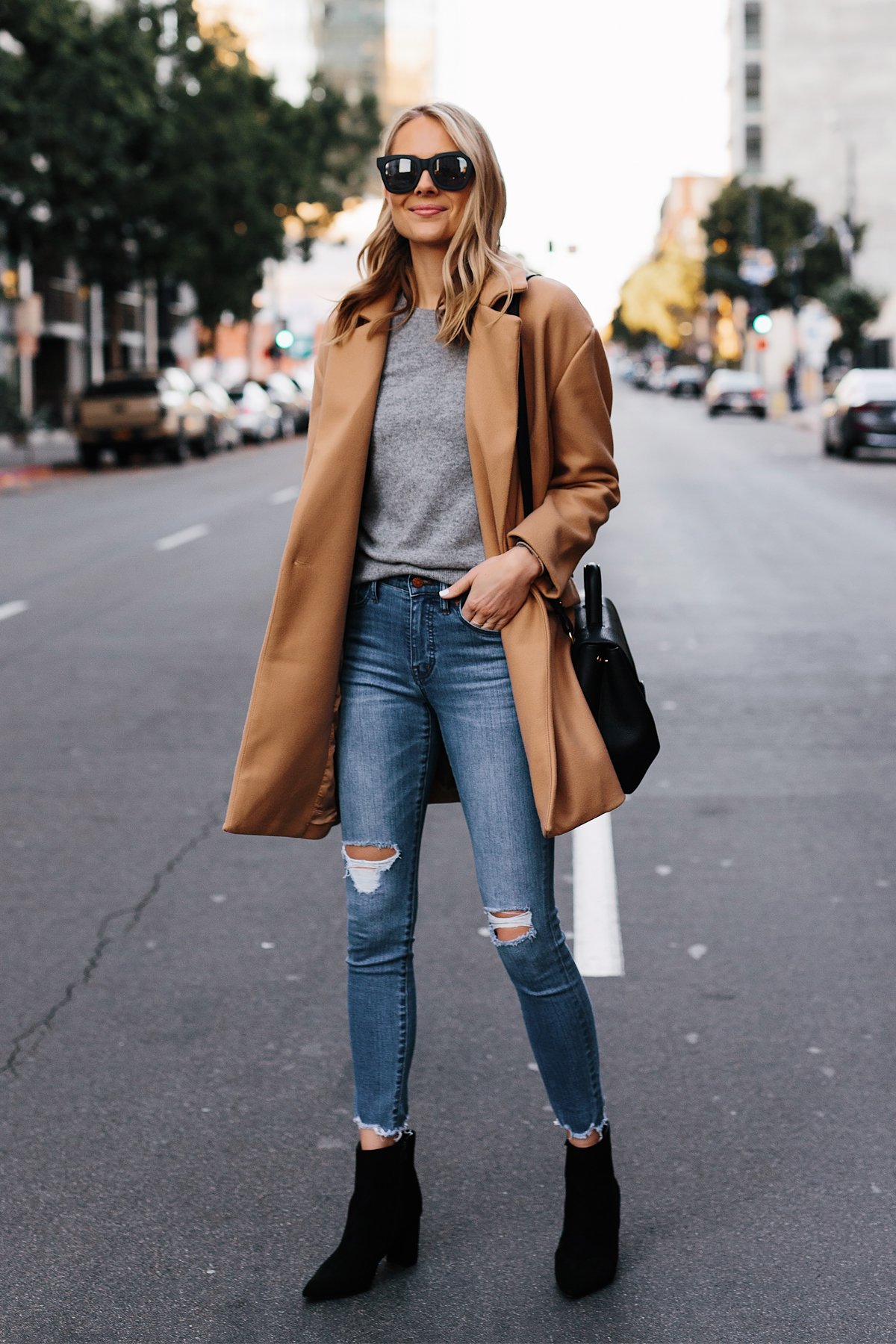 Blonde Woman Wearing Camel Coat Grey Sweater Denim Ripped Skinny Jeans Black Booties Outfit Fashion Jackson San Diego Fashion Blogger Street Style