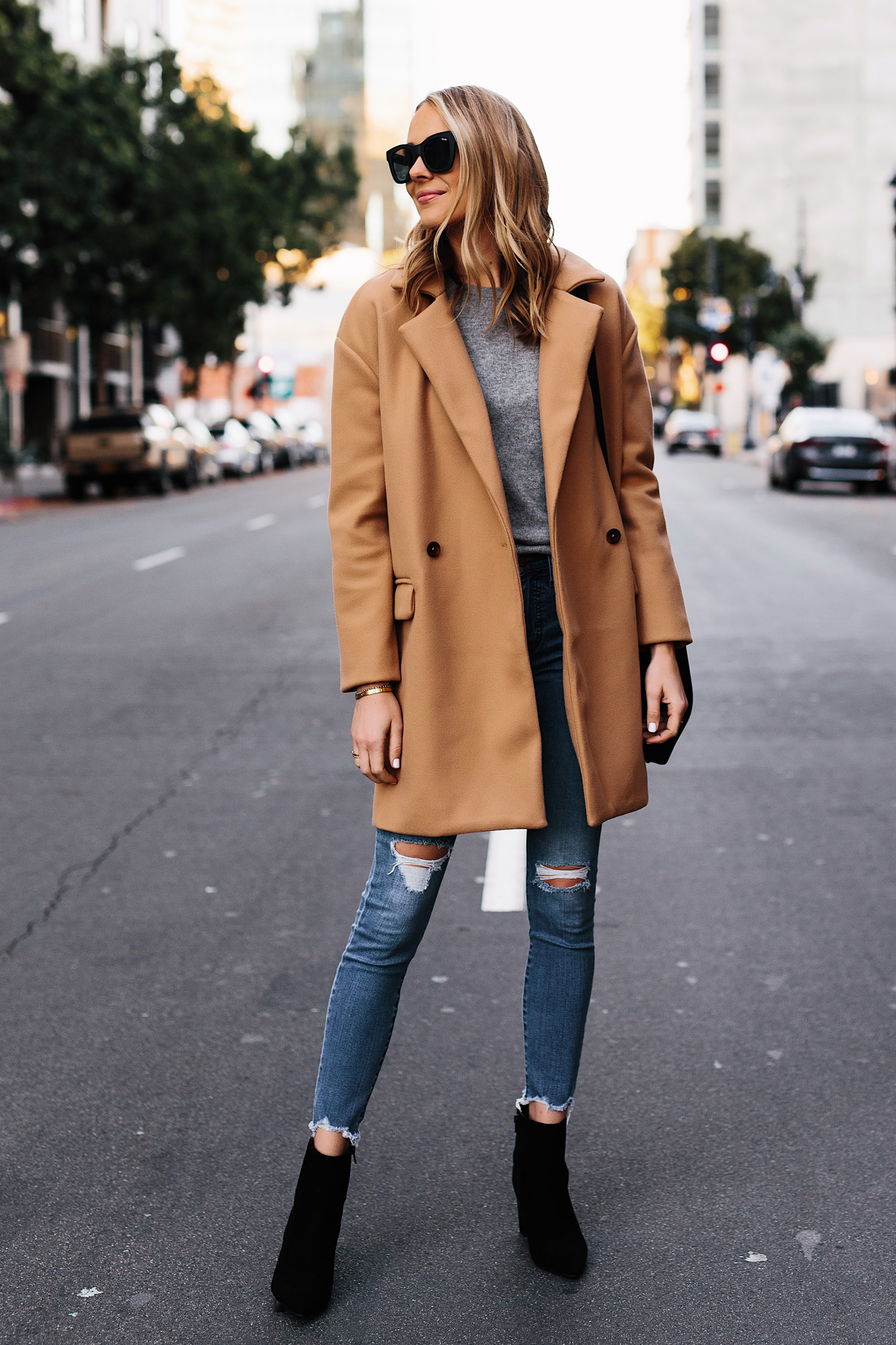 Blonde Woman Wearing Camel Coat Grey Sweater Denim Ripped Skinny Jeans Black Booties Outfit Fashion Jackson San Diego Fashion Blogger Street Style