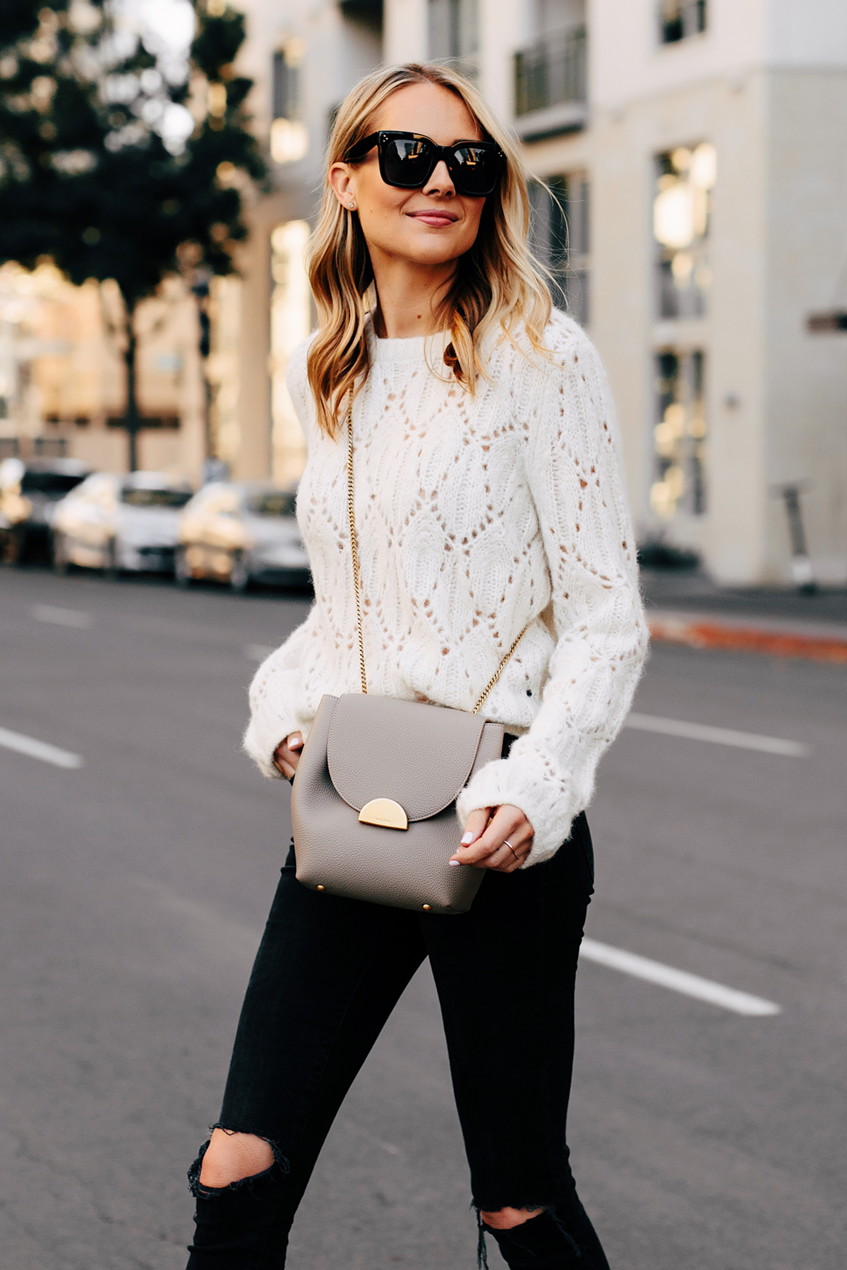 Blonde Woman Wearing Reformation White Pointelle Sweater Madewell Black Ripped Skinny Jeans Polene Grey Handbag Fashion Jackson San Diego Fashion Blogger Street Style