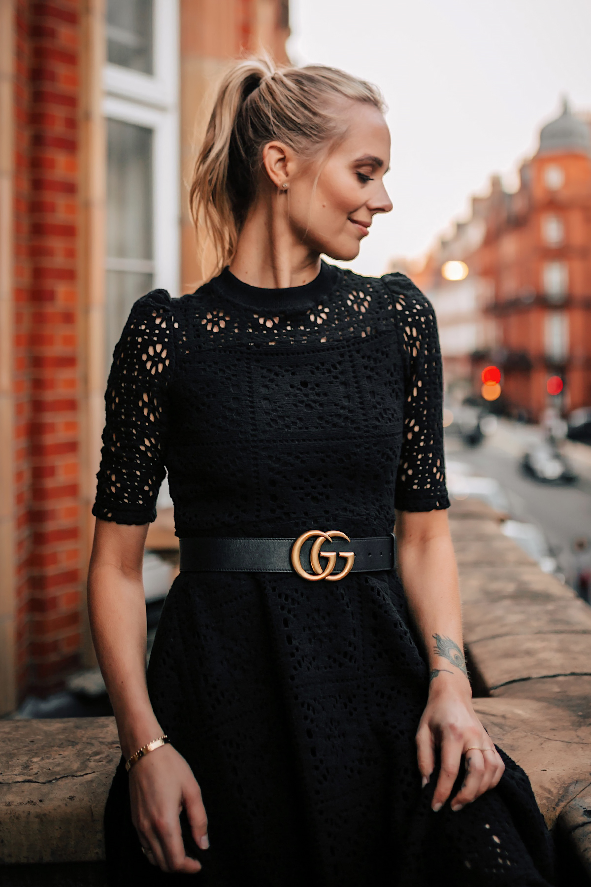 Blonde Women Wearing Black Lace Dress with Gucci Belt on London Balcony