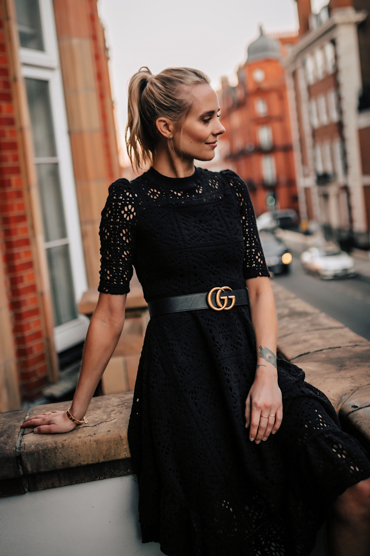 Blonde Women Wearing Black Lace Dress with Gucci Belt on London Balcony