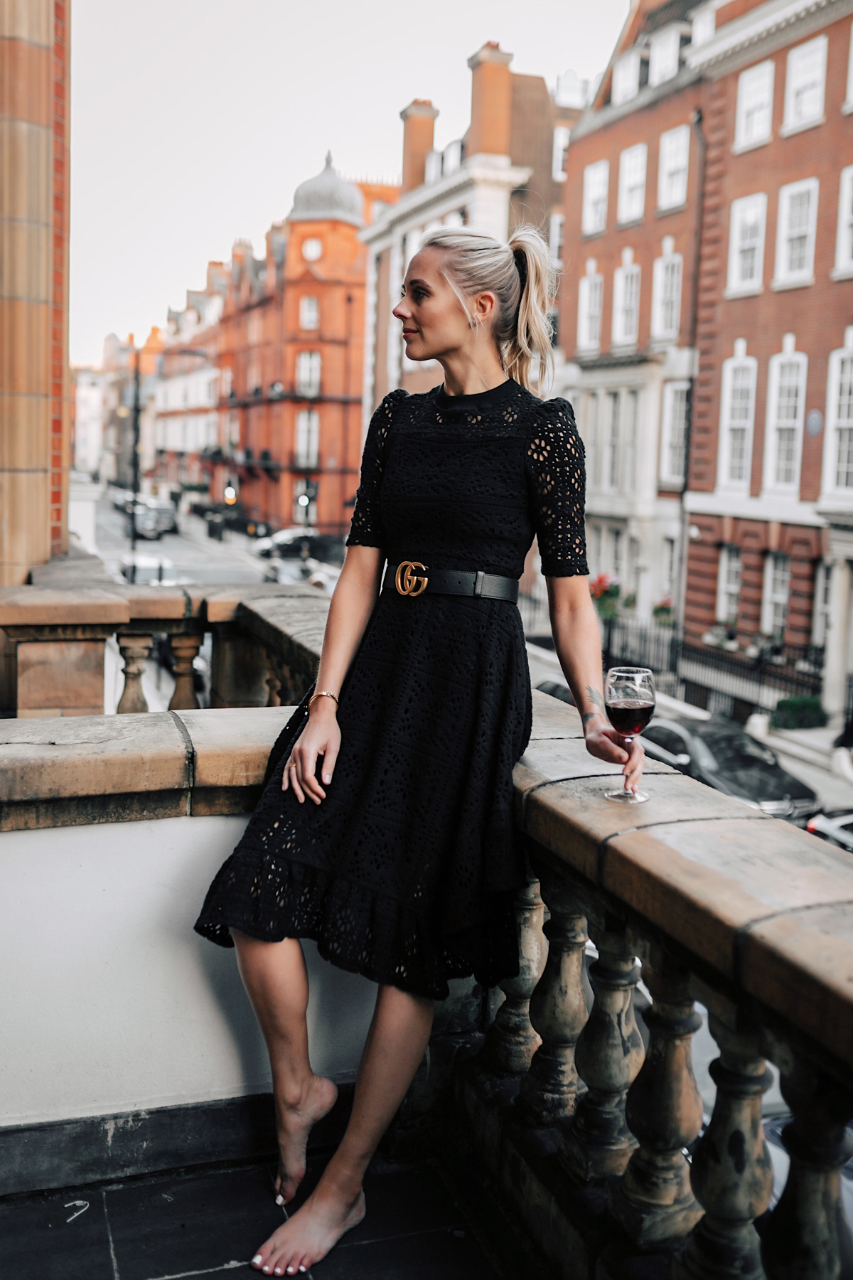 Blonde Women Wearing Black Lace Dress with Gucci Belt on London Balcony