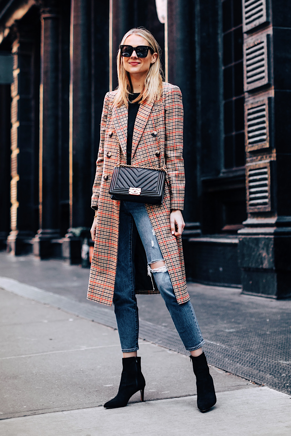 Blonde Woman Wearing Topshop Plaid Long Coat Black Sweater Levis Wedgie Fit Ripped Jeans Black Booties Chanel Boy Bag Black Fashion Jackson Fashion Blogger NYFW Street Style