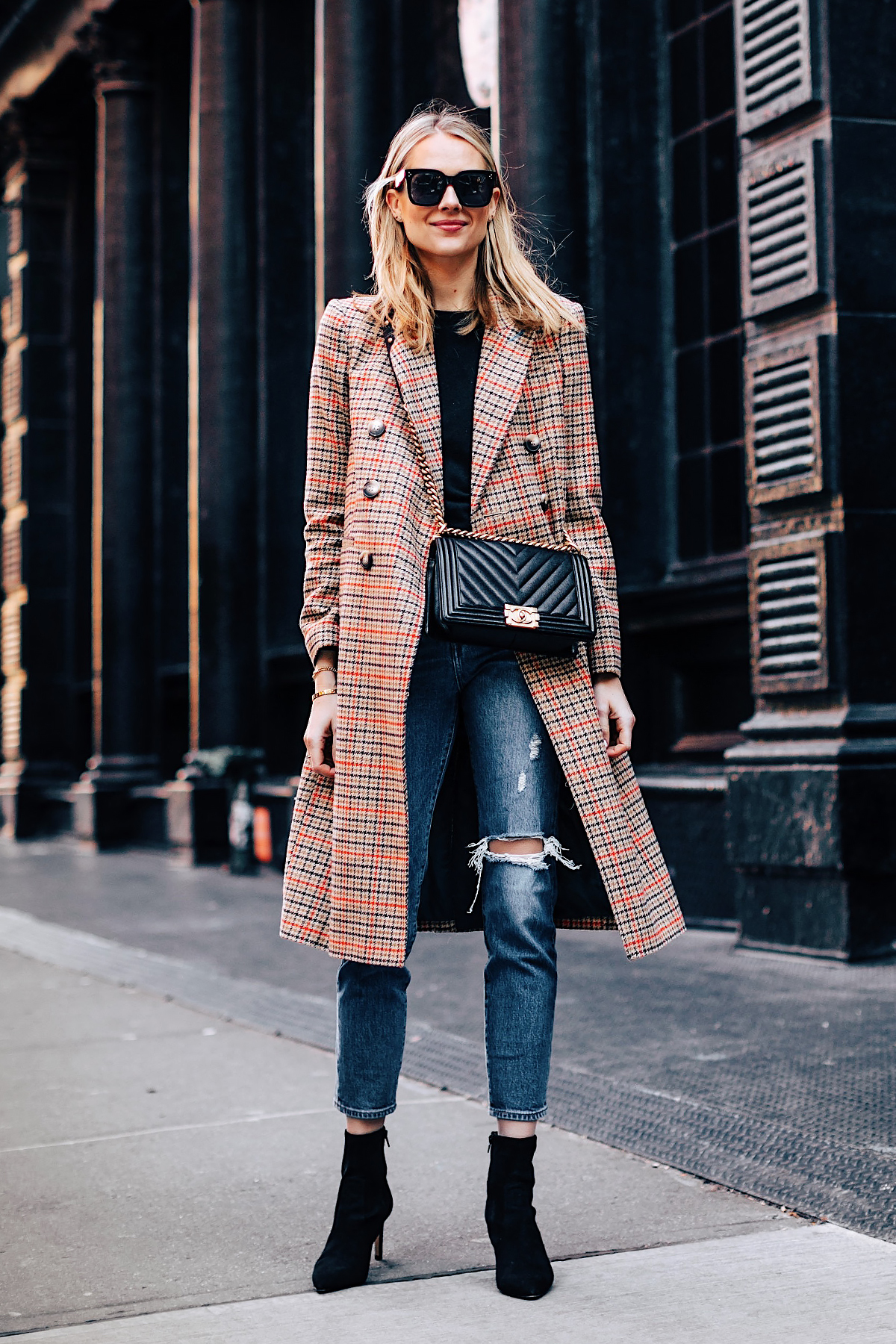 Blonde Woman Wearing Topshop Plaid Long Coat Black Sweater Levis Wedgie Fit Ripped Jeans Black Booties Chanel Boy Bag Black Fashion Jackson Fashion Blogger NYFW Street Style