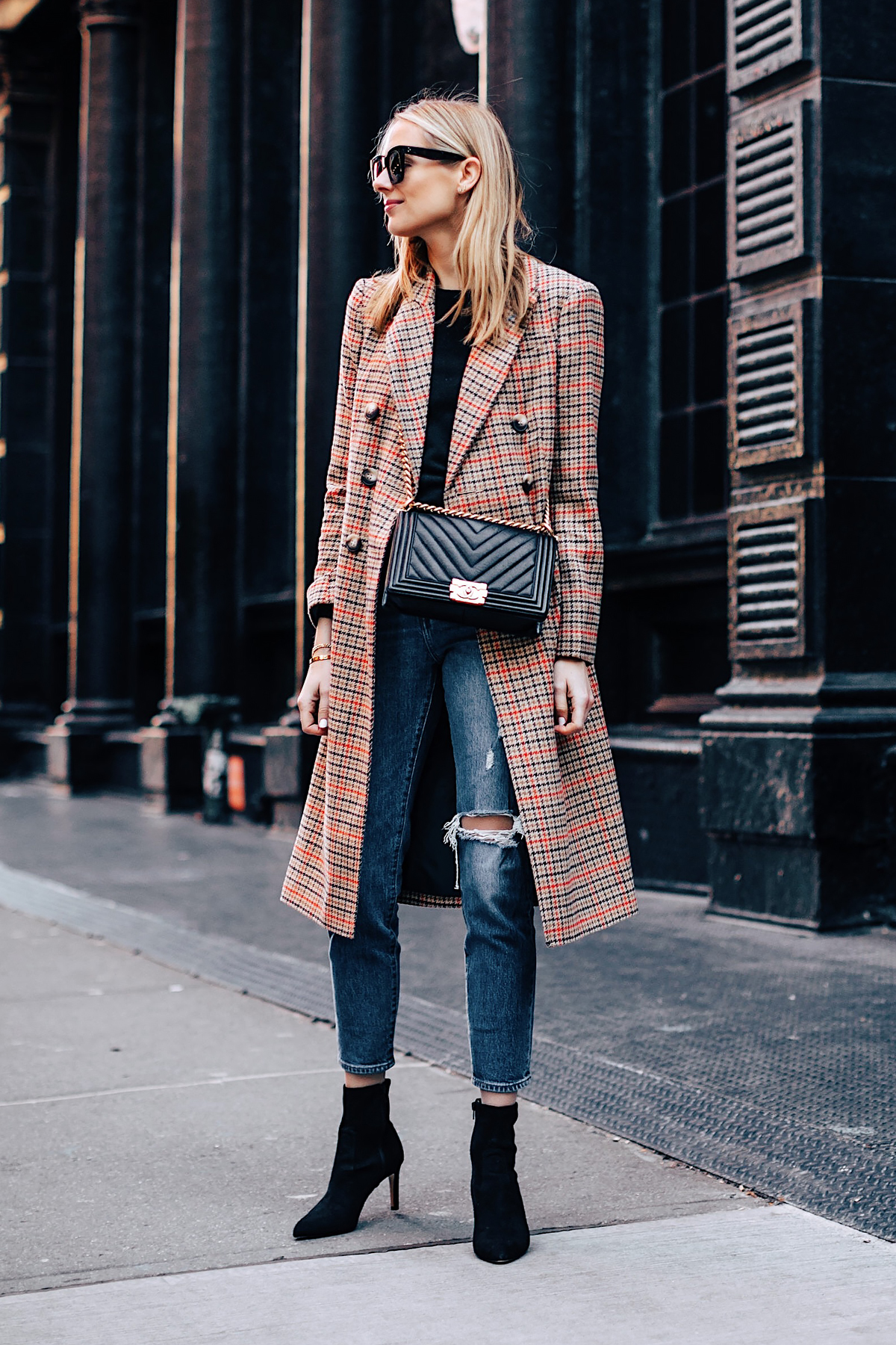 Blonde Woman Wearing Topshop Plaid Long Coat Black Sweater Levis Wedgie Fit Ripped Jeans Black Booties Chanel Boy Bag Black Fashion Jackson Fashion Blogger NYFW Street Style