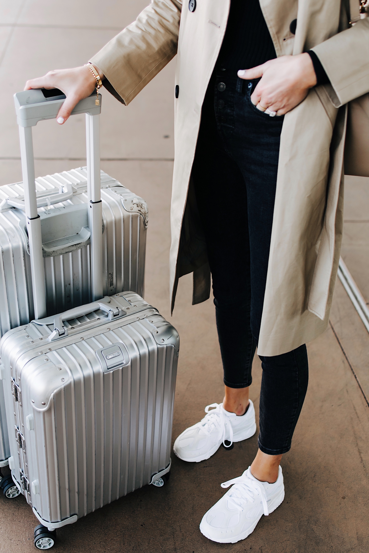 Woman Wearing Airport Travel Outfit Trench Coat Black Skinny Jeans Reebok Aztrek White Sneakers Rimowa Luggage Fashion Jackson San Diego Fashion Blogger Street Style