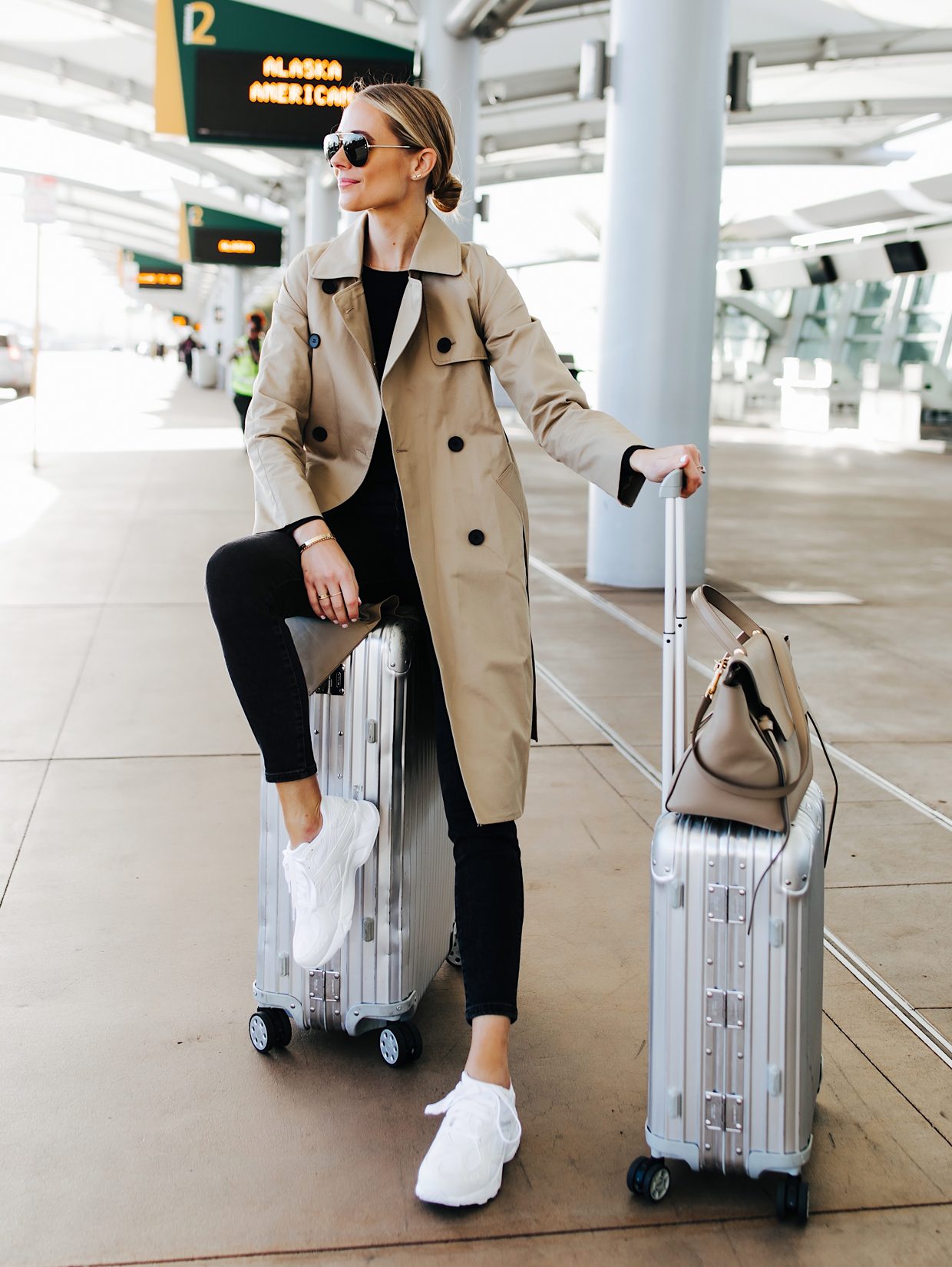 Fashion Jackson Airport Travel Outfit Trench Coat Black Skinny Jeans Reebok Aztrek White Sneakers Rimowa Luggage Featured Image