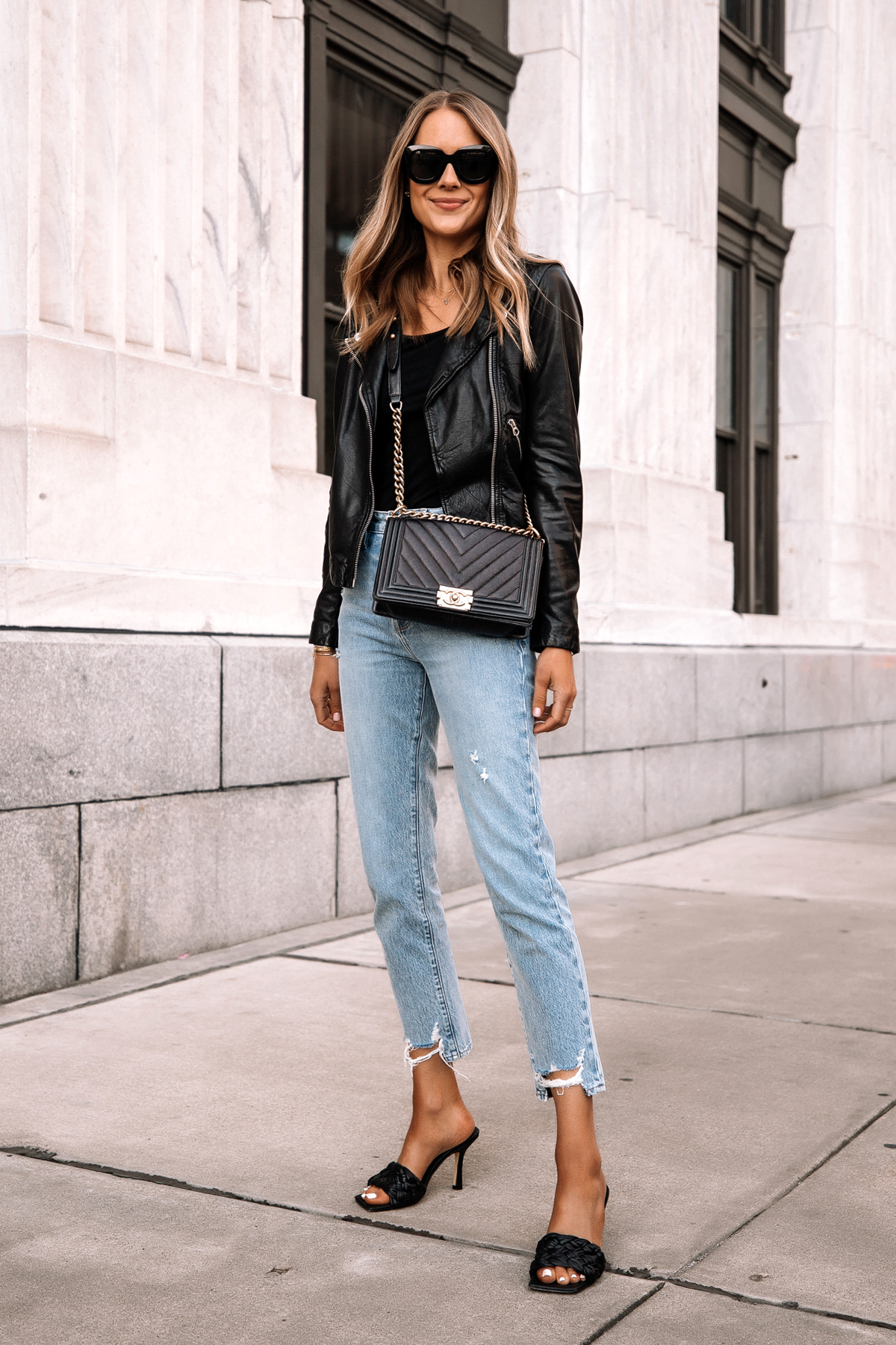 https://fashionjackson.com/wp-content/uploads/2019/03/Fashion-Jackson-Wearing-Madewell-Black-Leather-Jacket-Black-Bodysuit-Ripped-Jeans-Black-Woven-Heeled-Sandals-Chanel-Black-Boy-Bag-Street-Style-Outfit.jpg