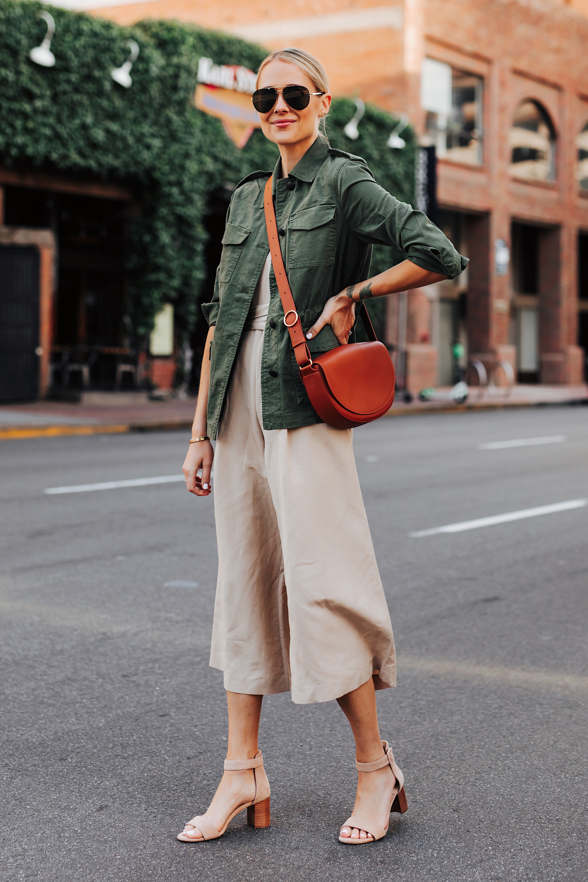 Blonde Woman Wearing Banana Republic Beige Linen Jumpsuit Green Utility Jacket Tan Sandals Tan Handbag Fashion Jackson San Diego Fashion Blogger Street Style