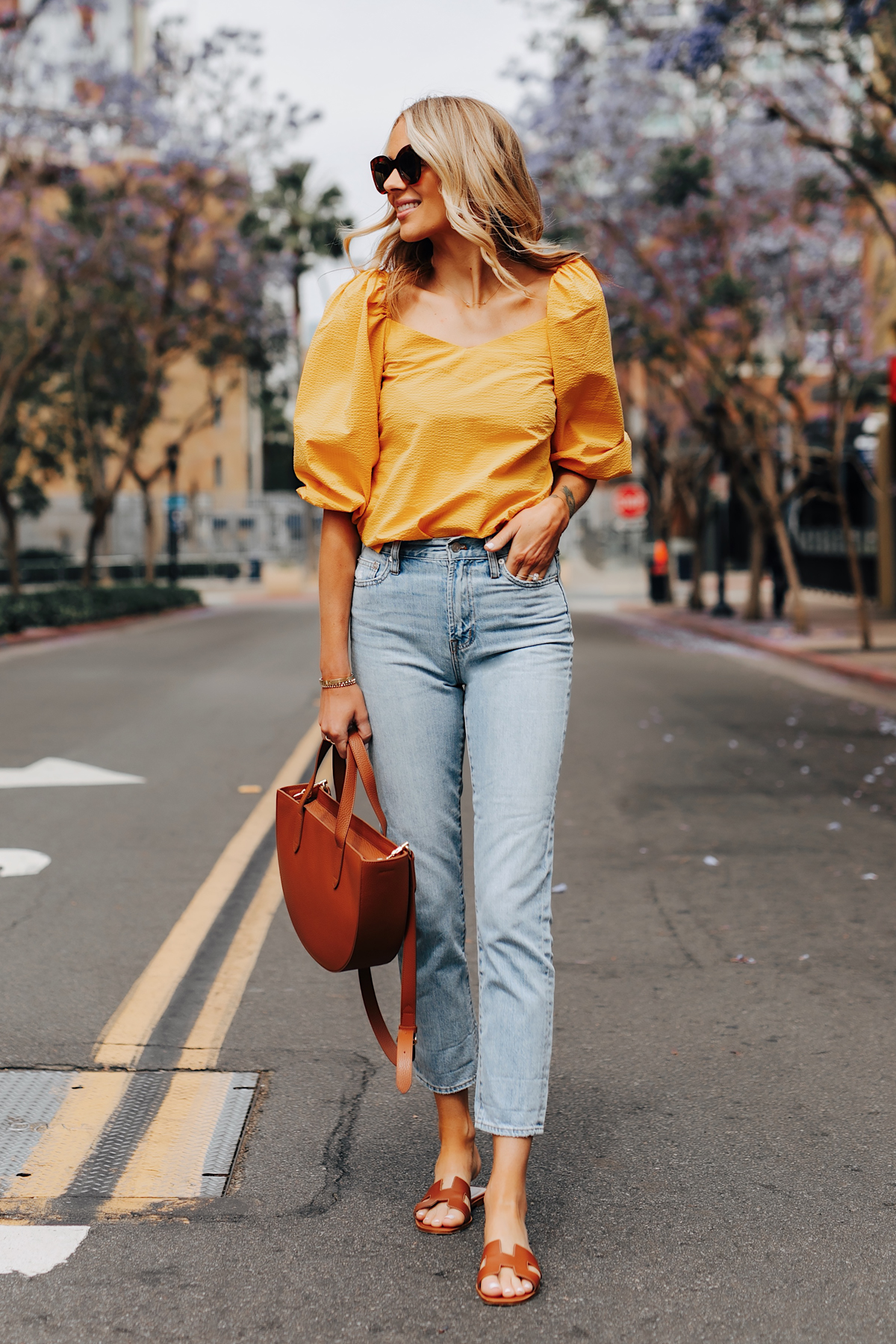 Fashion Jackson Wearing Cuyana Yellow Blouse Denim Ankle Jeans Hermes Oran Gold Sandals Cuyana Tan Handbag