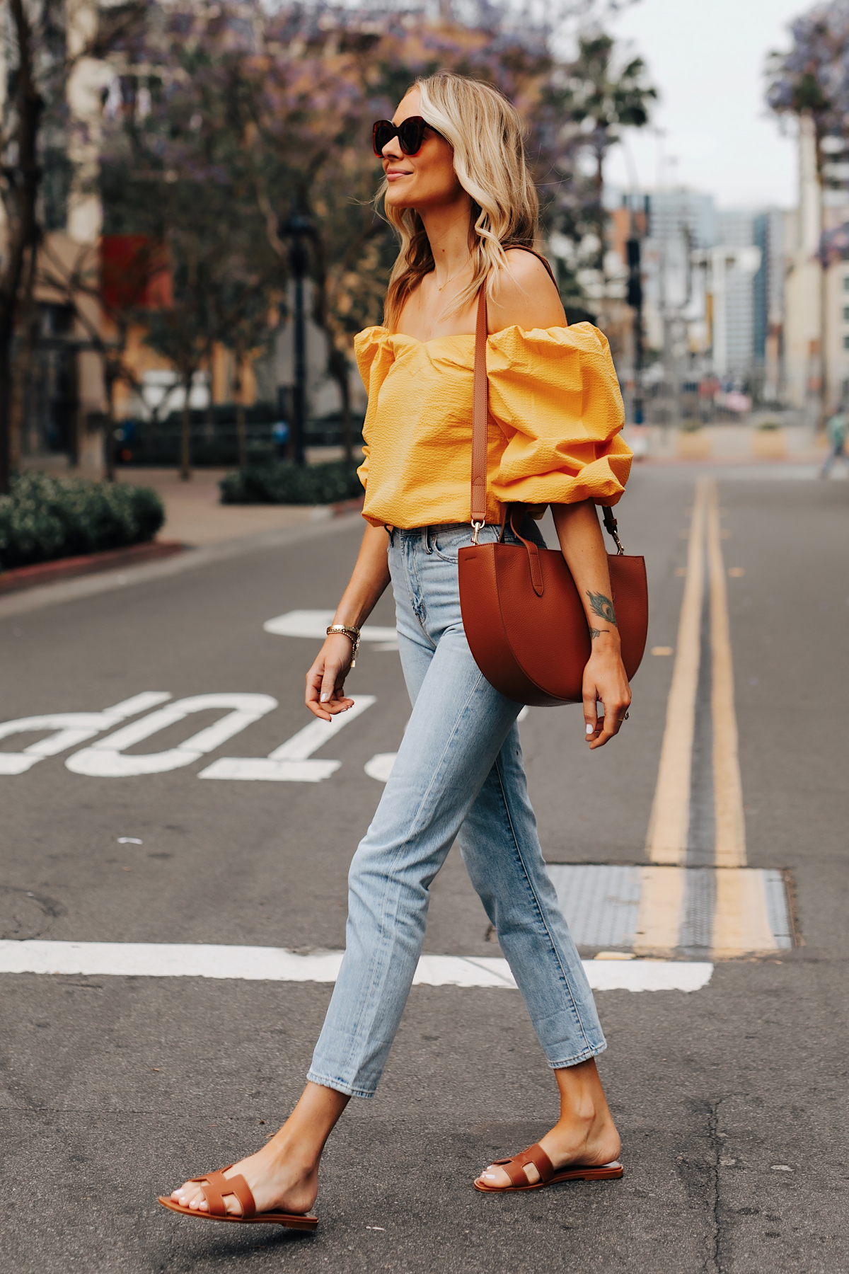 Fashion Jackson Wearing Cuyana Yellow Off the Shoulder Blouse Denim Ankle Jeans Hermes Oran Gold Sandals Cuyana Tan Handbag