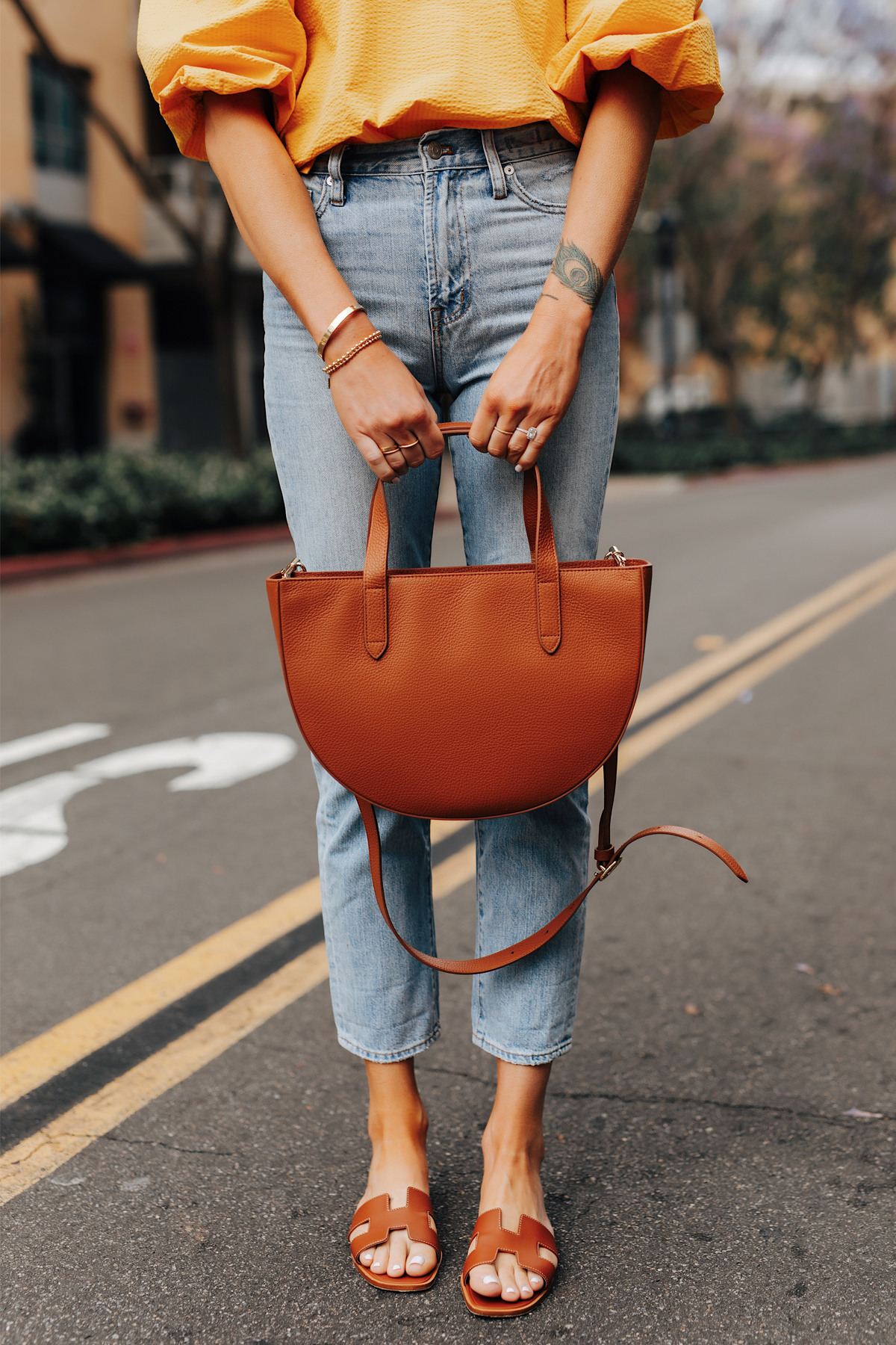 Fashion Jackson Wearing Denim Ankle Jeans Hermes Oran Gold Sandals Cuyana Tan Semi Circle Handbag