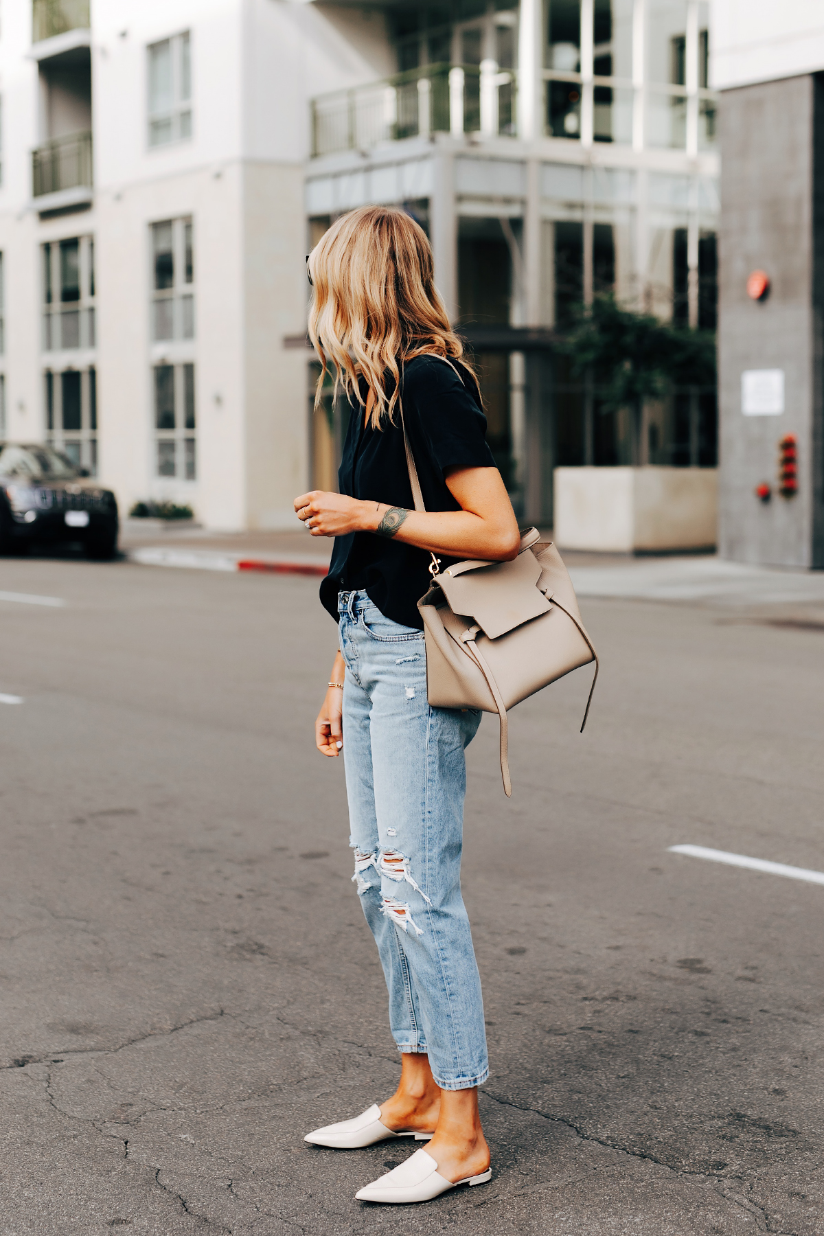 Fashion Jackson Wearing Everlane Short Sleeve Black Top Everlane Ripped Boyfriend Jeans Everlane White Mules Celine Belt Bag