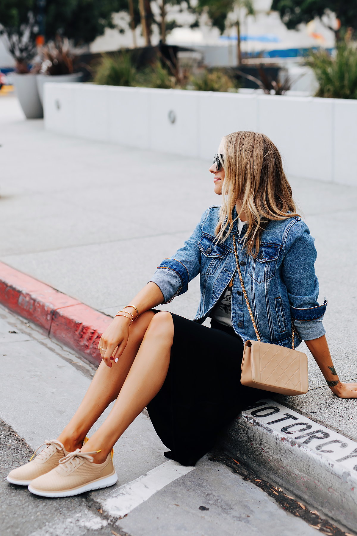 Fashion Jackson Sitting Wearing Denim Jacket Graphic Tshirt Black Slip Midi Skirt Tan Sneakers Tan Chanel Handbag