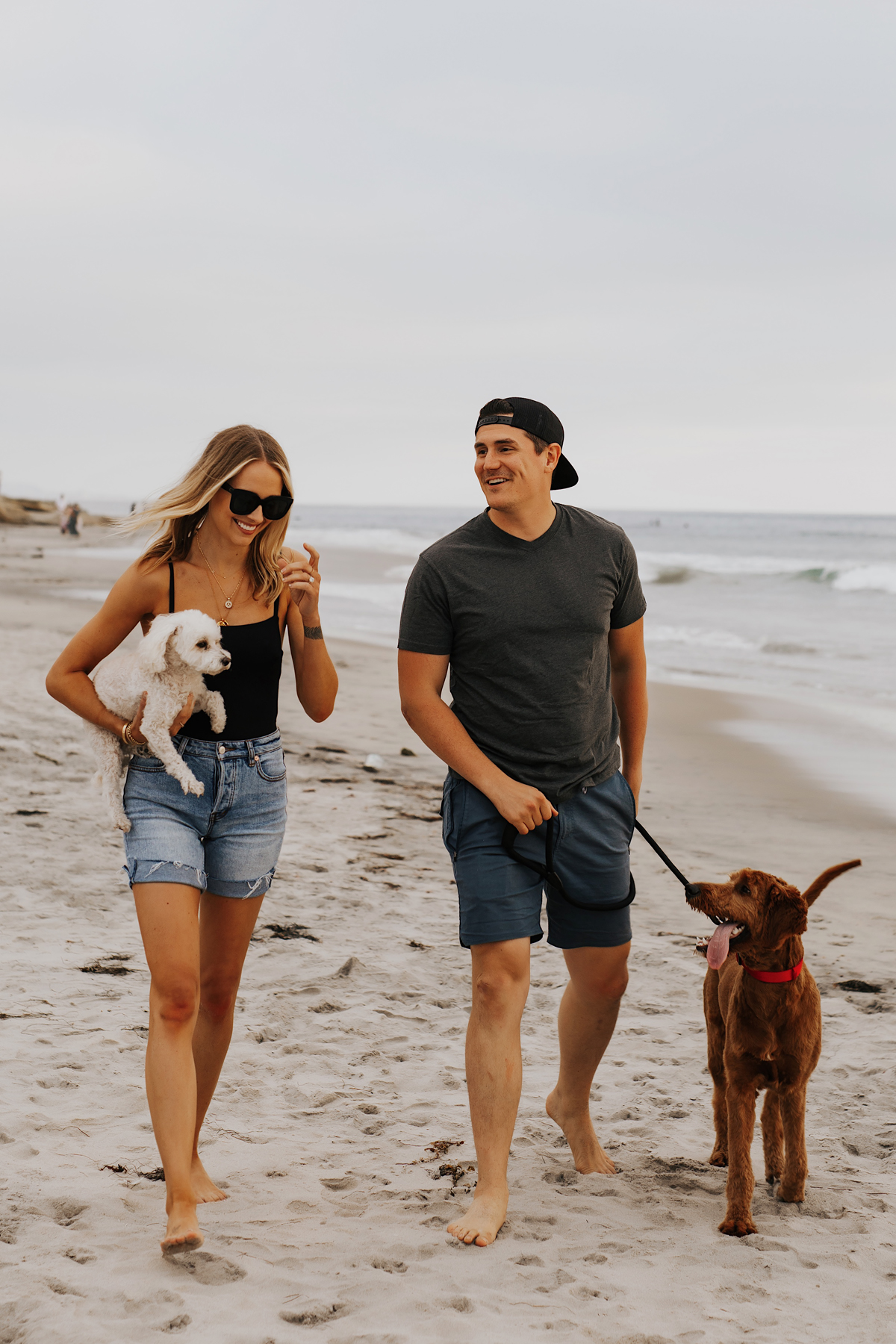 Fashion Jackson Wearing Black One Piece Swimsuit Long Denim Shorts Will Wearing Tshirt Roark Shorts with dogs at San Diego Dog Beach