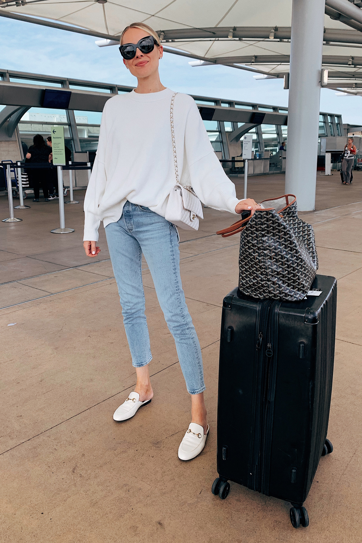 Fashion Jackson Wearing Free People White Tunic Sweater Levis High Rise Jeans White Gucci Muules White Chanel Handbag Calpak Luggage Goyard Tote Airport Outfit Travel Outfit