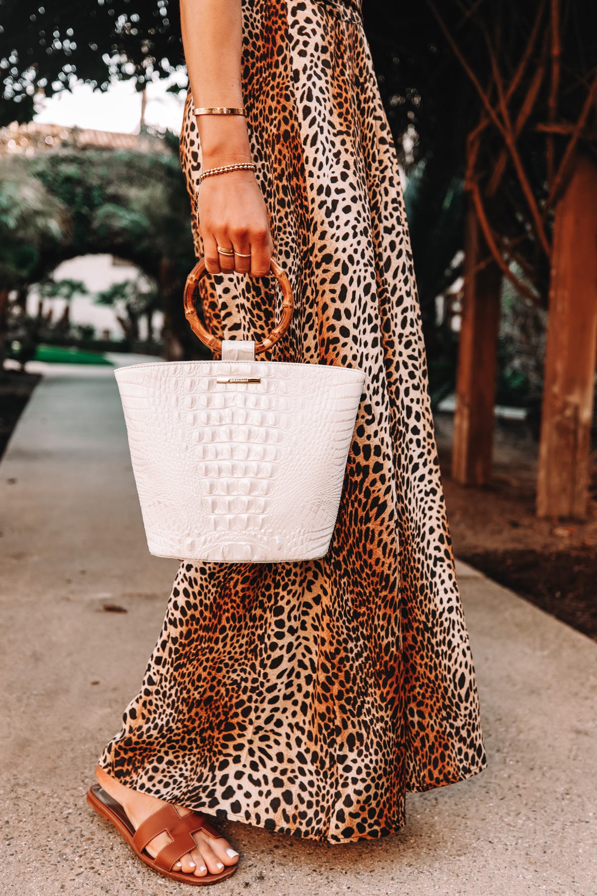 Fashion Jackson Wearing Leopard Maxi Dress Holding Brahmin Mod Bowie Handbag in White Hermes Oran Sandals Brown