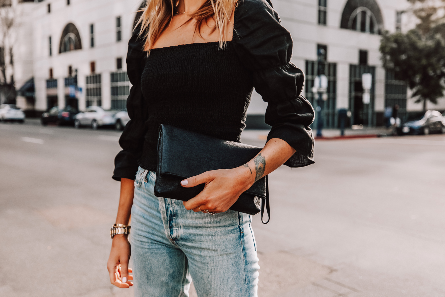 Fashion Jackson Wearing Black Puff Sleeve Rouched Top Black Clutch Jeans