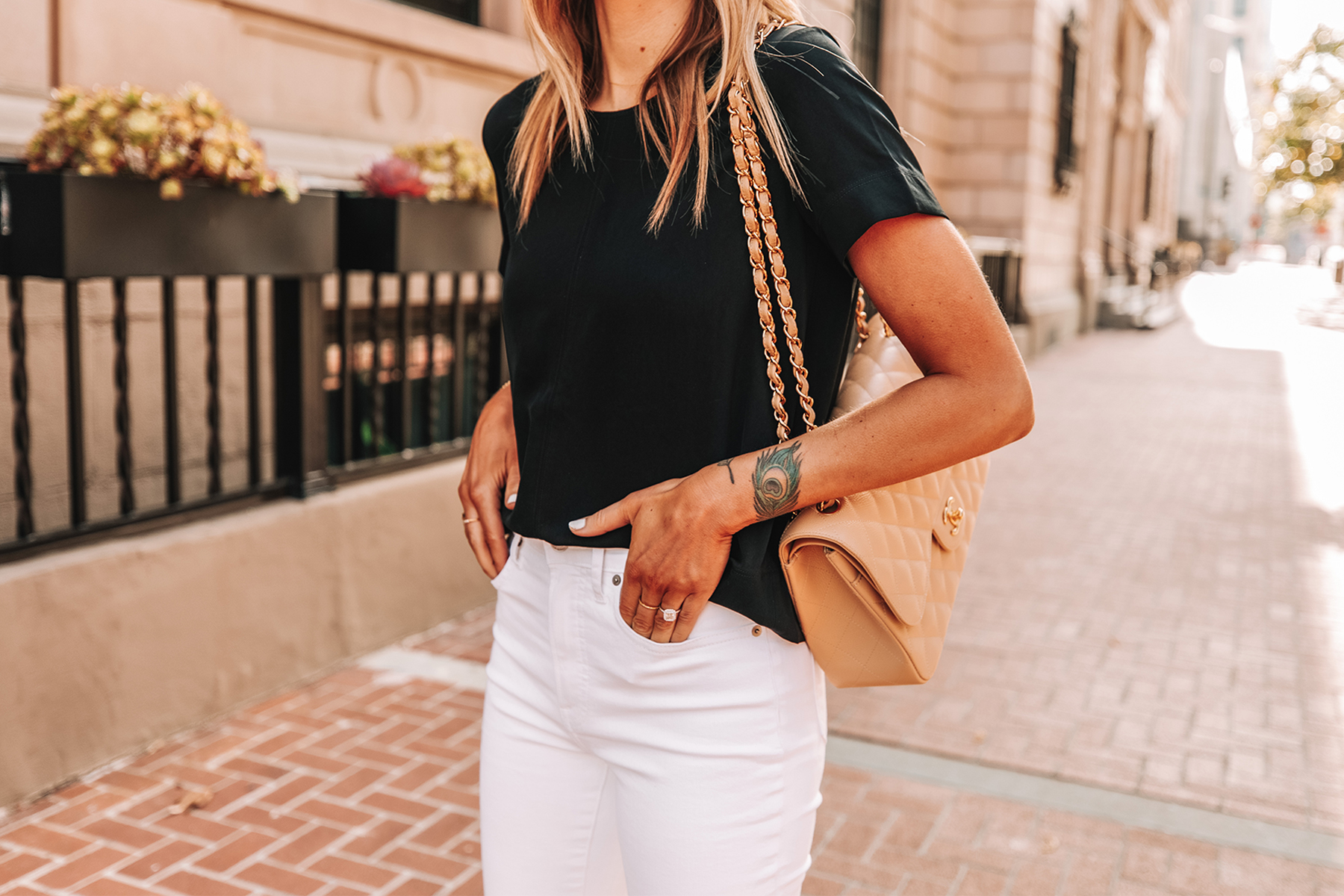 Fahsion Jackson Wearing Everlane Black Short Sleeve Top White High Rise Jeans Chanel Beige Handbag