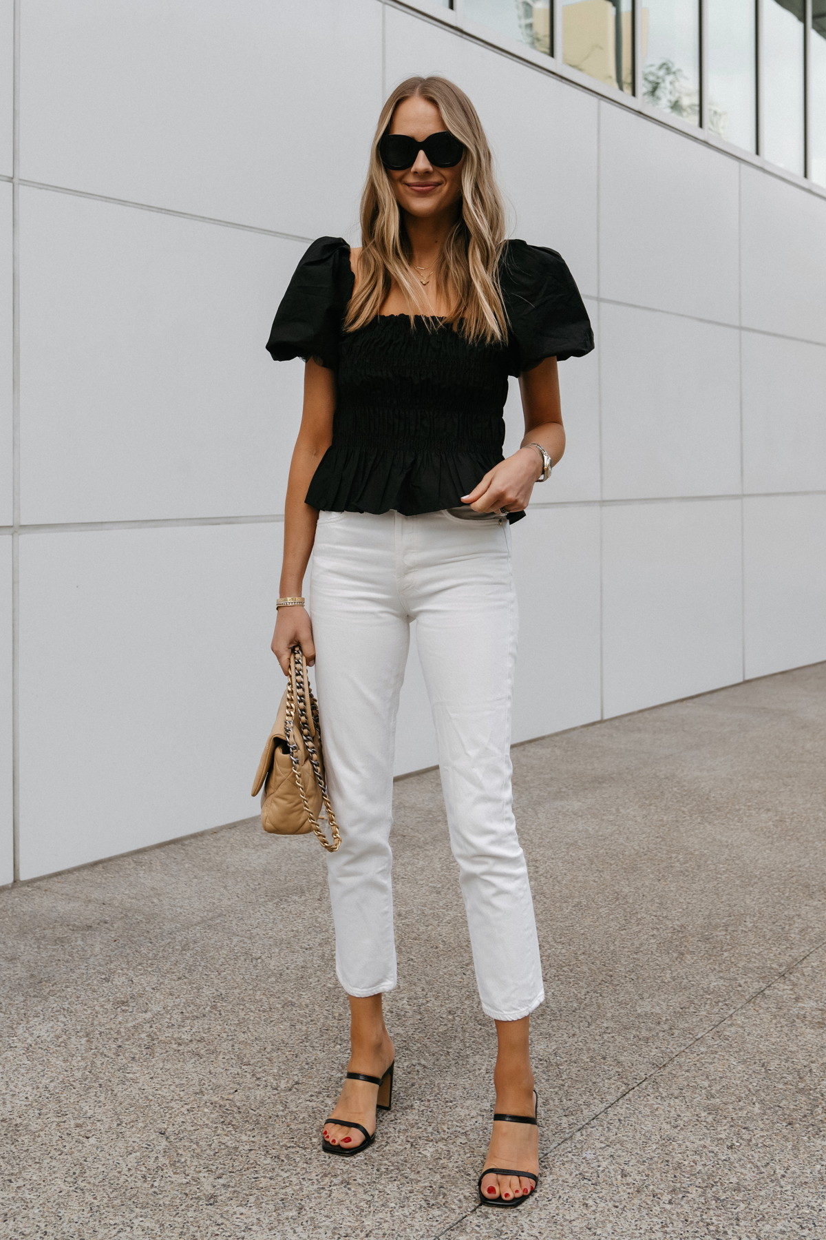 Fashion Jackson Wearing Smocked Black Puff Sleeve Top White Jeans Black Heeled Sandals Chanel 19 Beige Handbag Street Style