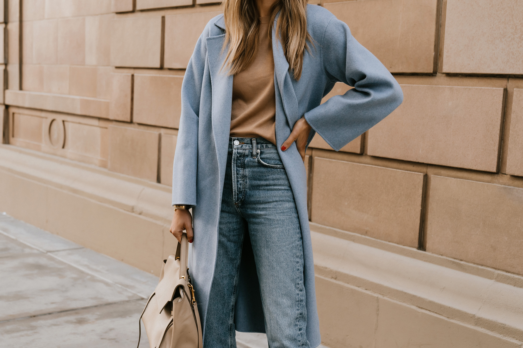 karina wears coated jeans with camel coat and ysl belt bag