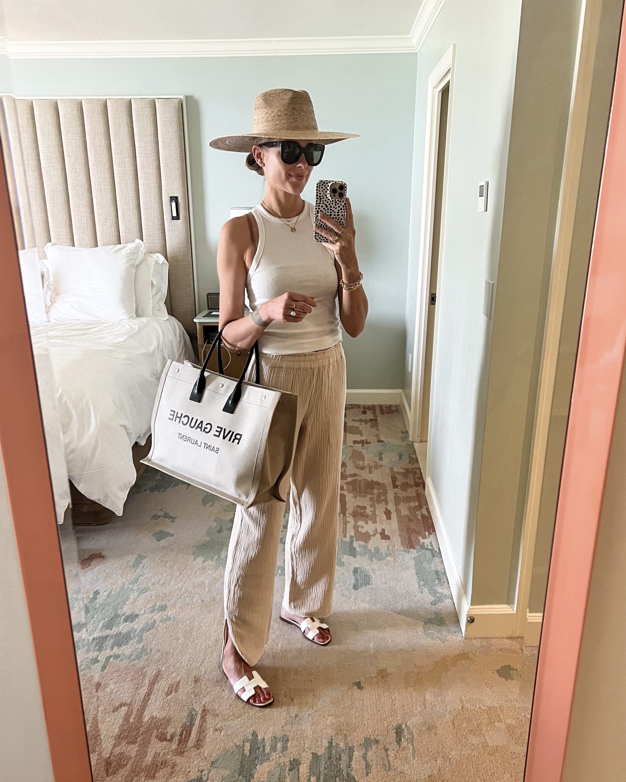 Fashion Jackson Wearing Anine Bing White Tank Tan Gauze Wide Leg Pants White Hermes Sandals Oversized Straw Hat Saint Laurent Tote Pool Outfit Beach Outfit Palm Beach