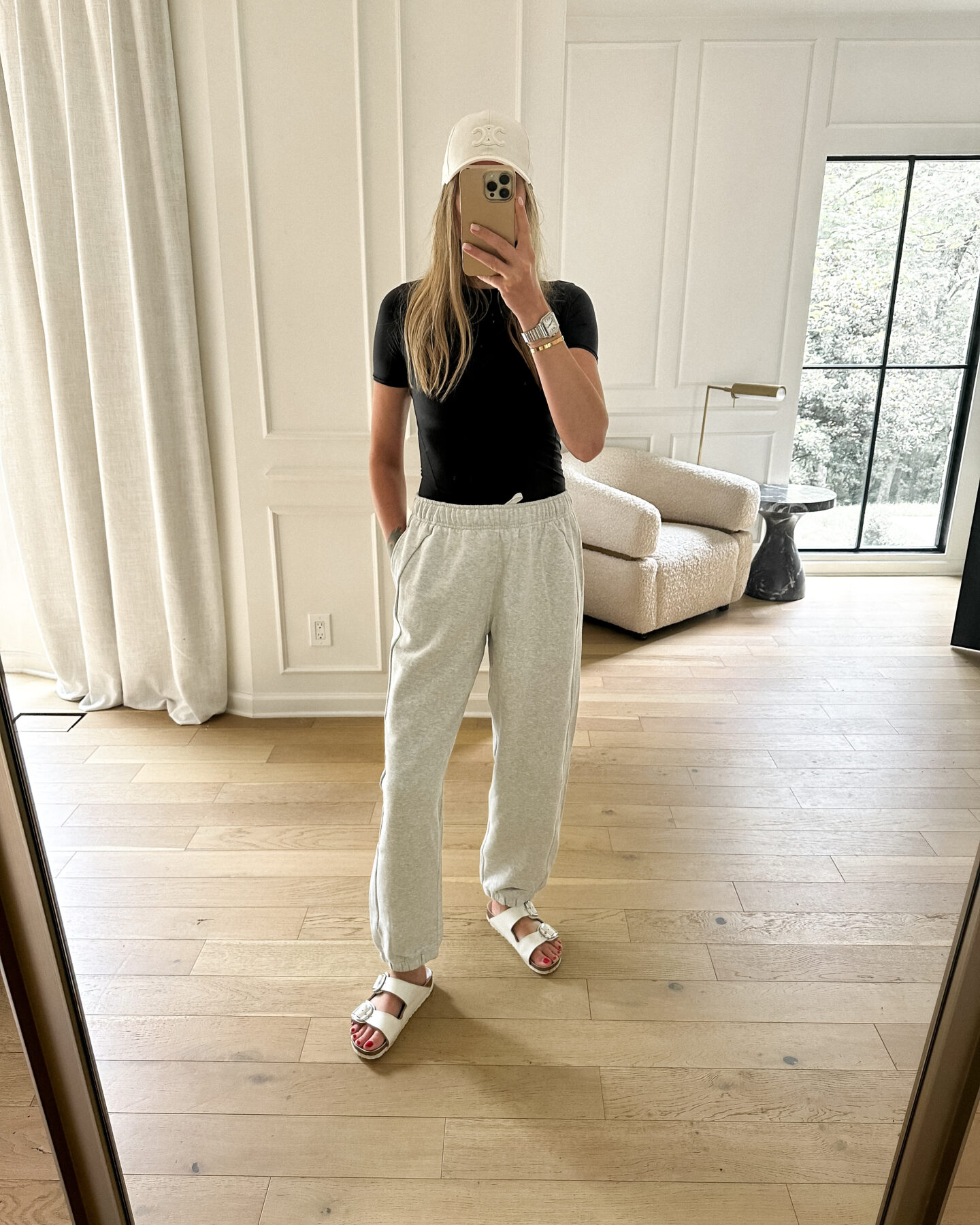 fashion jackson wearing lululemon grey joggers black tee white celine hat white birkenstock arizona big buckle sandals