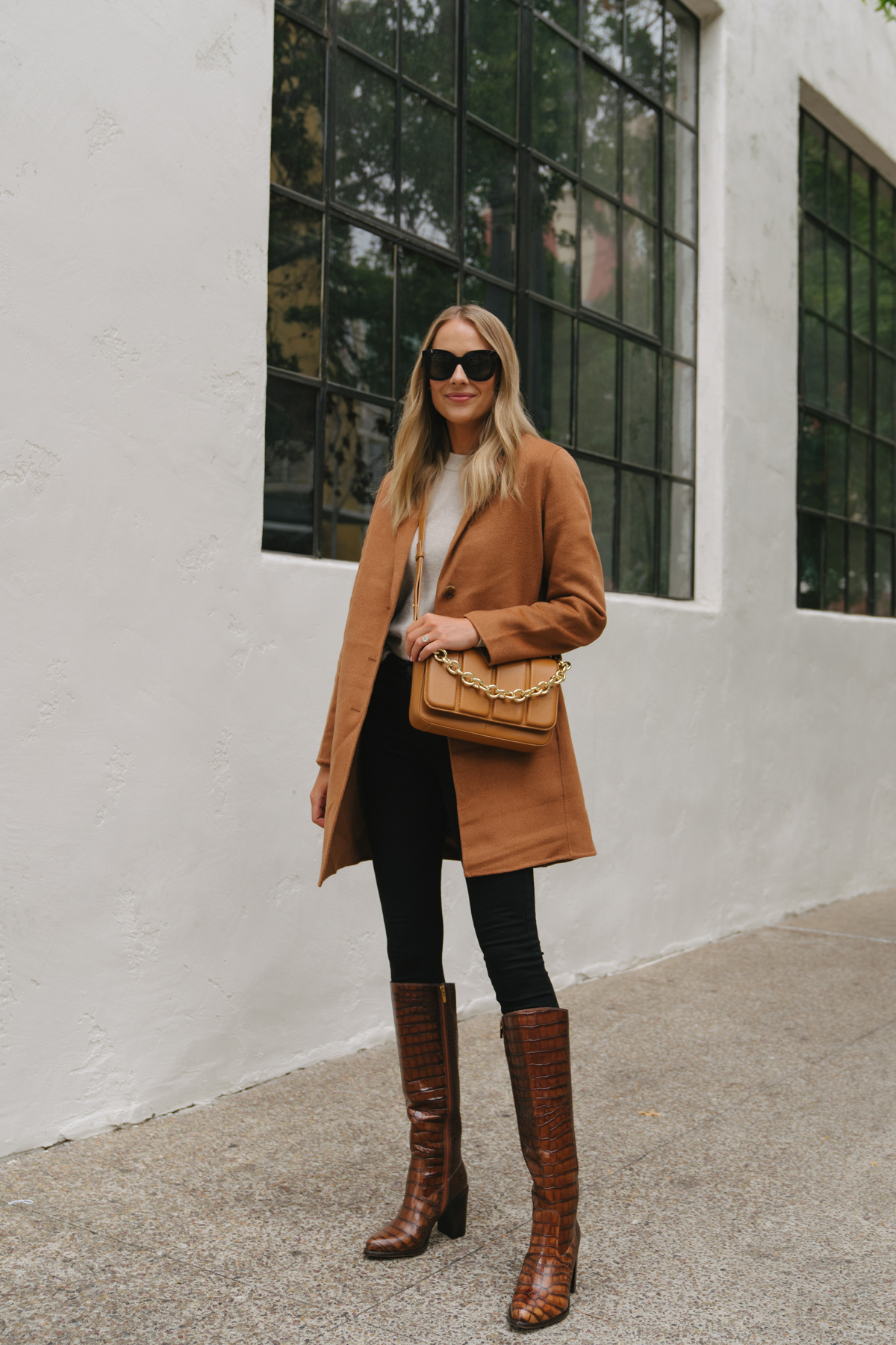 Fashion Jackson Wearing Camel Coat Beige Sweater Black Jeans Vince Camuto Tan Croc Knee High Boots Tan Crossbody Handbag