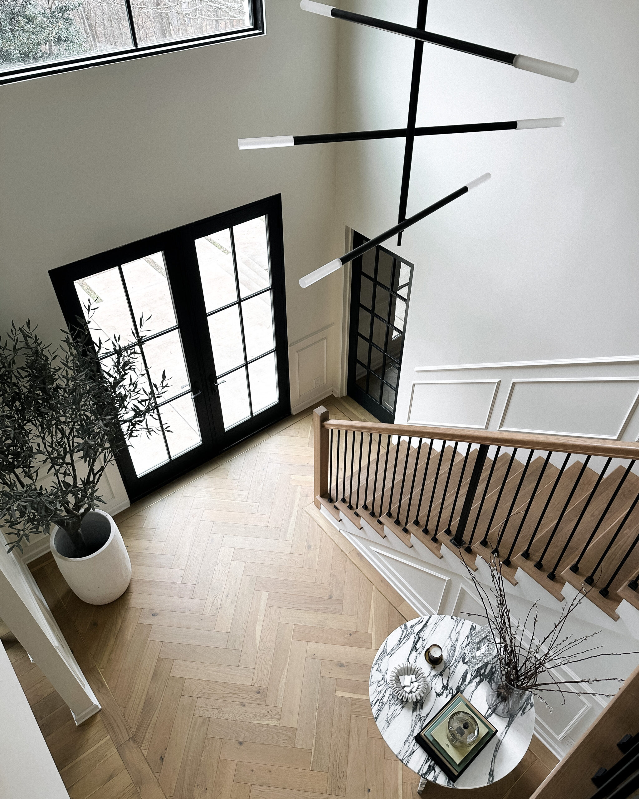 Fashion Jackson Home Renovation Transitional Home Chevron Wood Floors Entryway Staircase Kelly Wearstler Light Fixture Restoration Hardware Faux Olive Tree