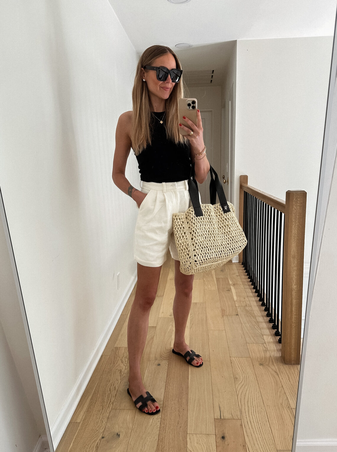 Fashion Jackson Wearing Black Tank Anine Bing White Shorts Hermes Black Sandals Raffia Tote Handbag Summer Outfit