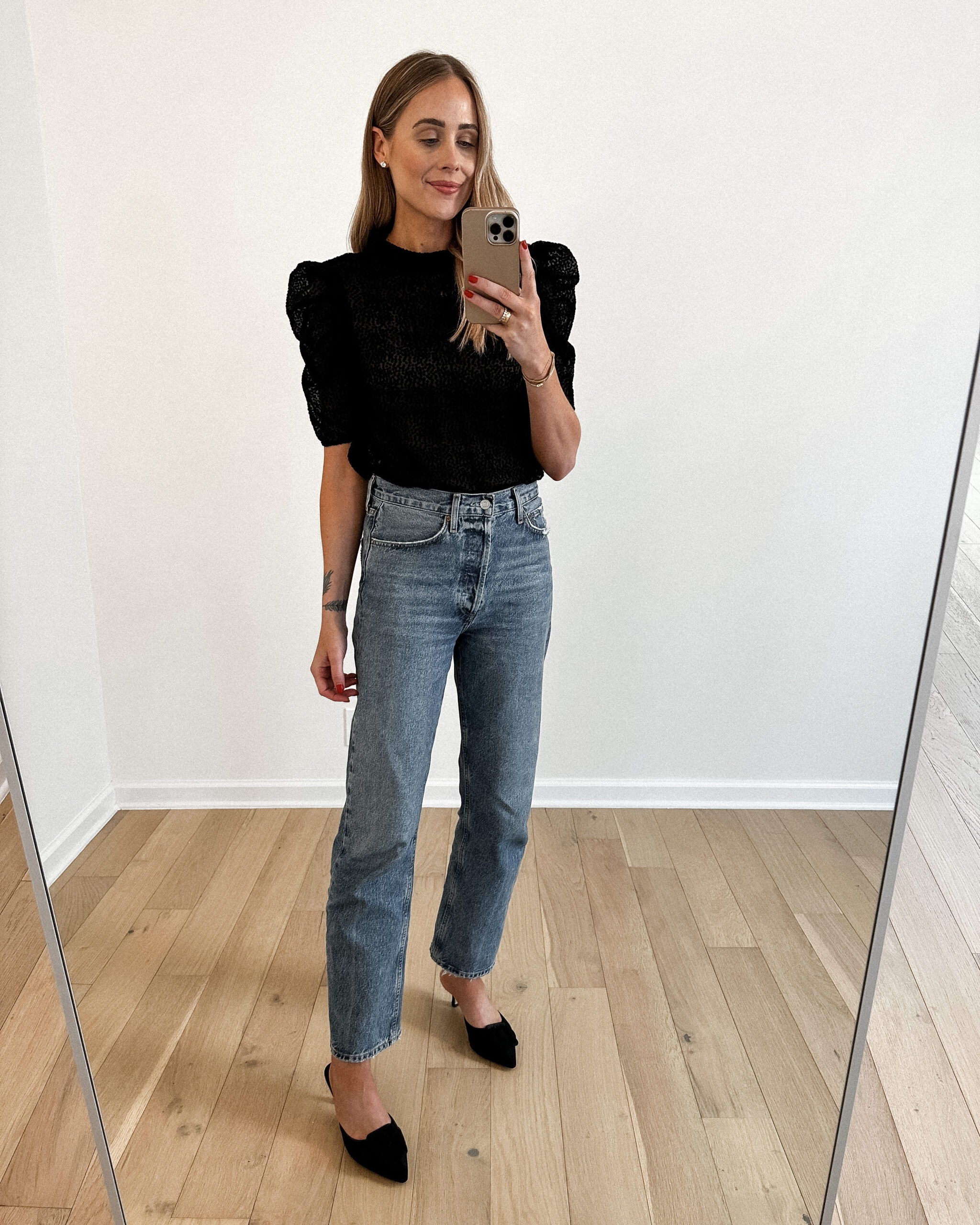 Fashion Jackson Wearing Black Sheer Puff Sleeve Top, AGOLDE denim jeans, Black Mules, Fall Business Casual Outfit, Fall Date Night Outfit